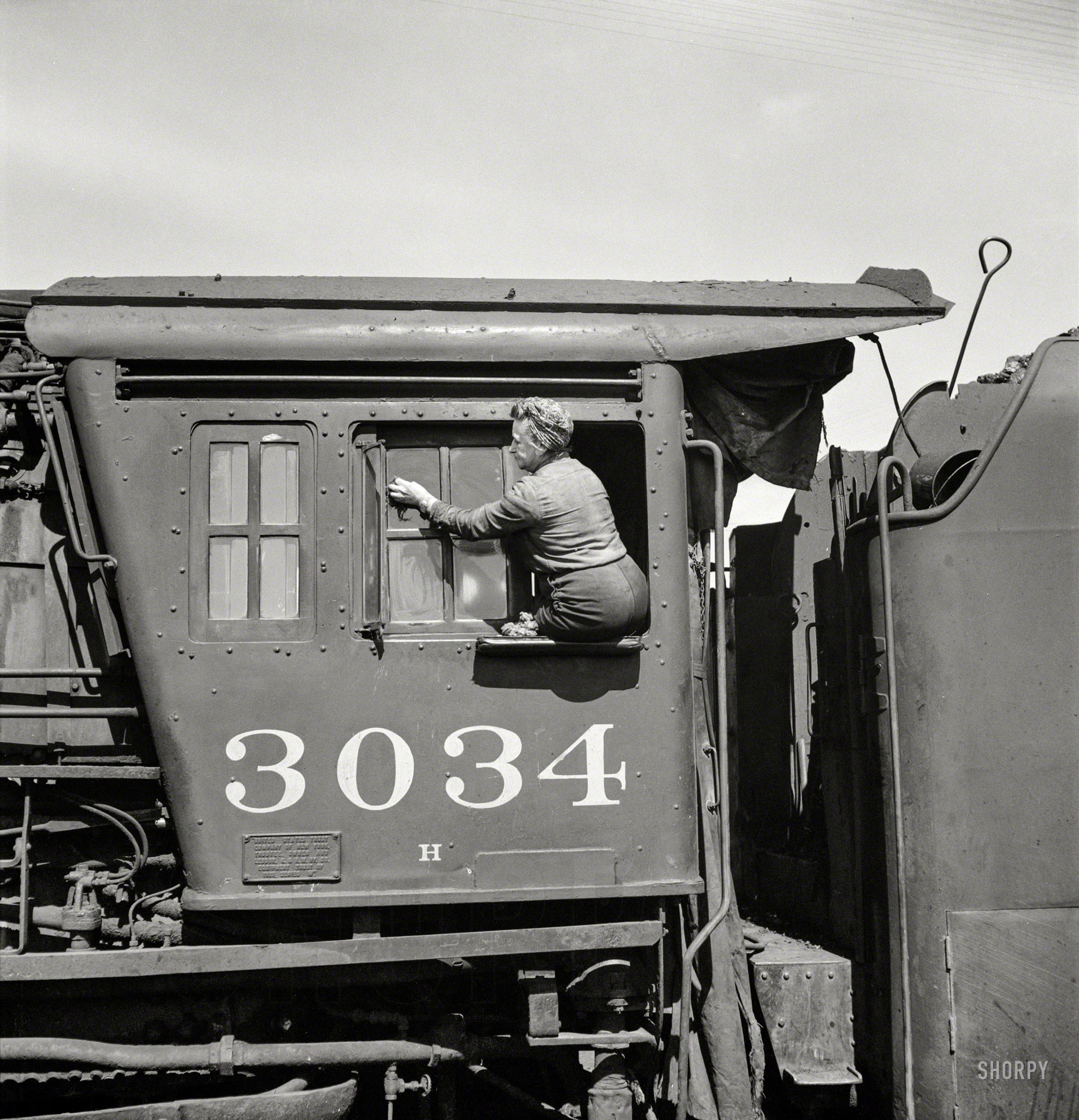 May 1943. "Clinton, Iowa. Women wipers of the Chicago & North Western cleaning one of the giant freight locomotives." Medium-format negative by Jack Delano for the Office of War Information. View full size.