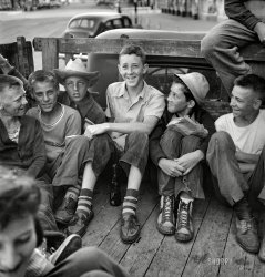 June 1943. Oswego, New York. "Children, recruited for farm work, waiting outside the U.S. Employment Service to start work for the summer." Photo by Marjory Collins for the Office of War Information. View full size.