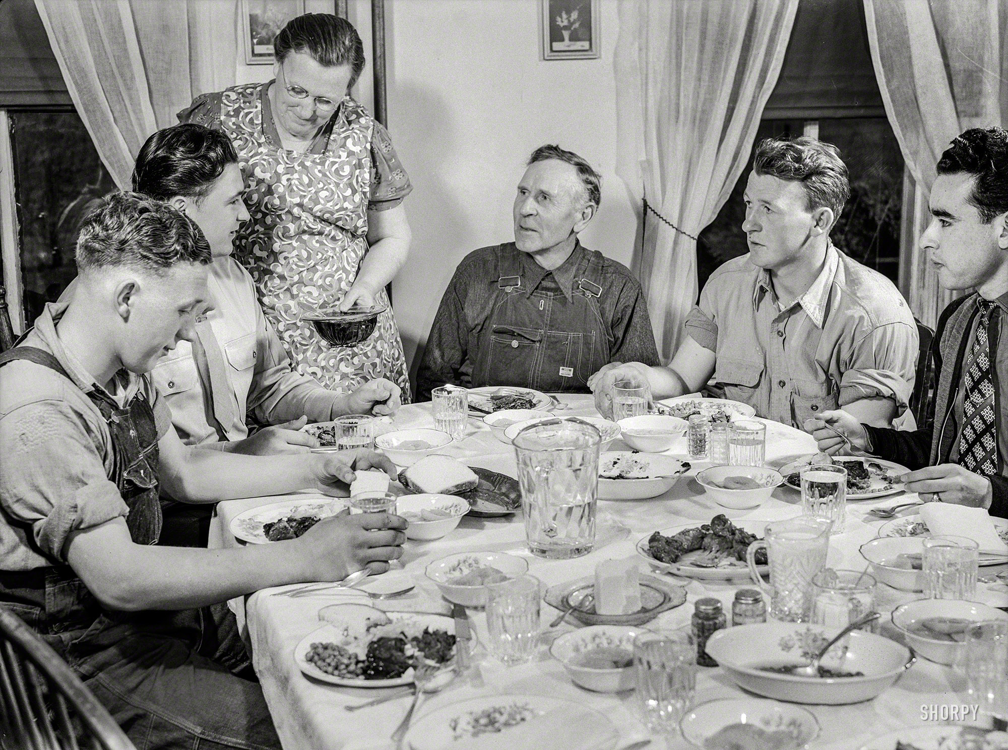 July 1943. "Rockville, Maryland (vicinity). Private Harvey Horton, visiting the N.C. Stiles dairy farm while on furlough from Fort Belvoir, Virginia, at dinner with the family." Including, at left, 16-year-old Charles Stiles. Photo by Ann Rosener for the Office of War Information. View full size.