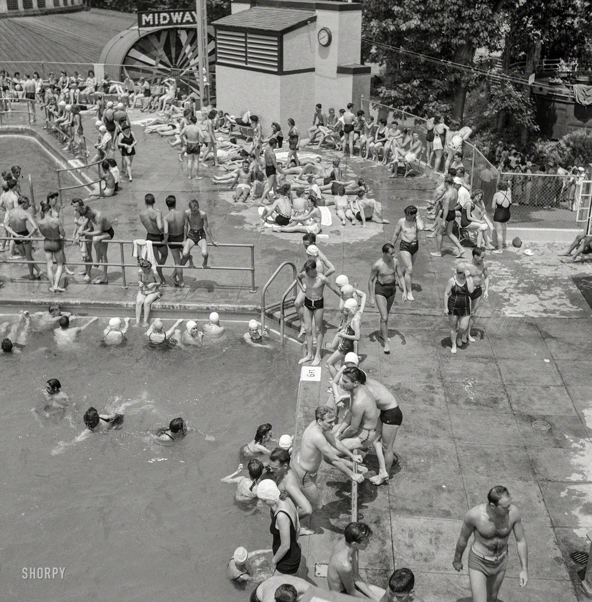 July 1943. Glen Echo, Maryland. "Swimming pool in the Glen Echo amusement park." Where most of the swimsuits aren't swimming. Medium-format negative by Esther Bubley for the Office of War Information. View full size.