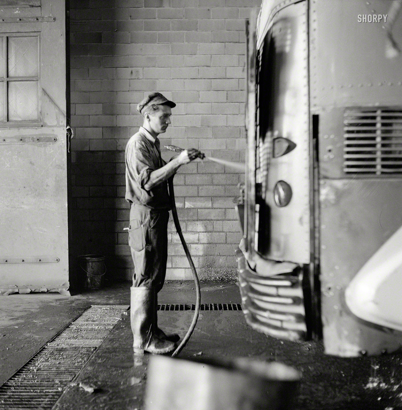 September 1943. "Pittsburgh, Pennsylvania. Bus serviceman washing a coach which has just come in from a run in the Greyhound garage." Photo by Esther Bubley for the Office of War Information. View full size.