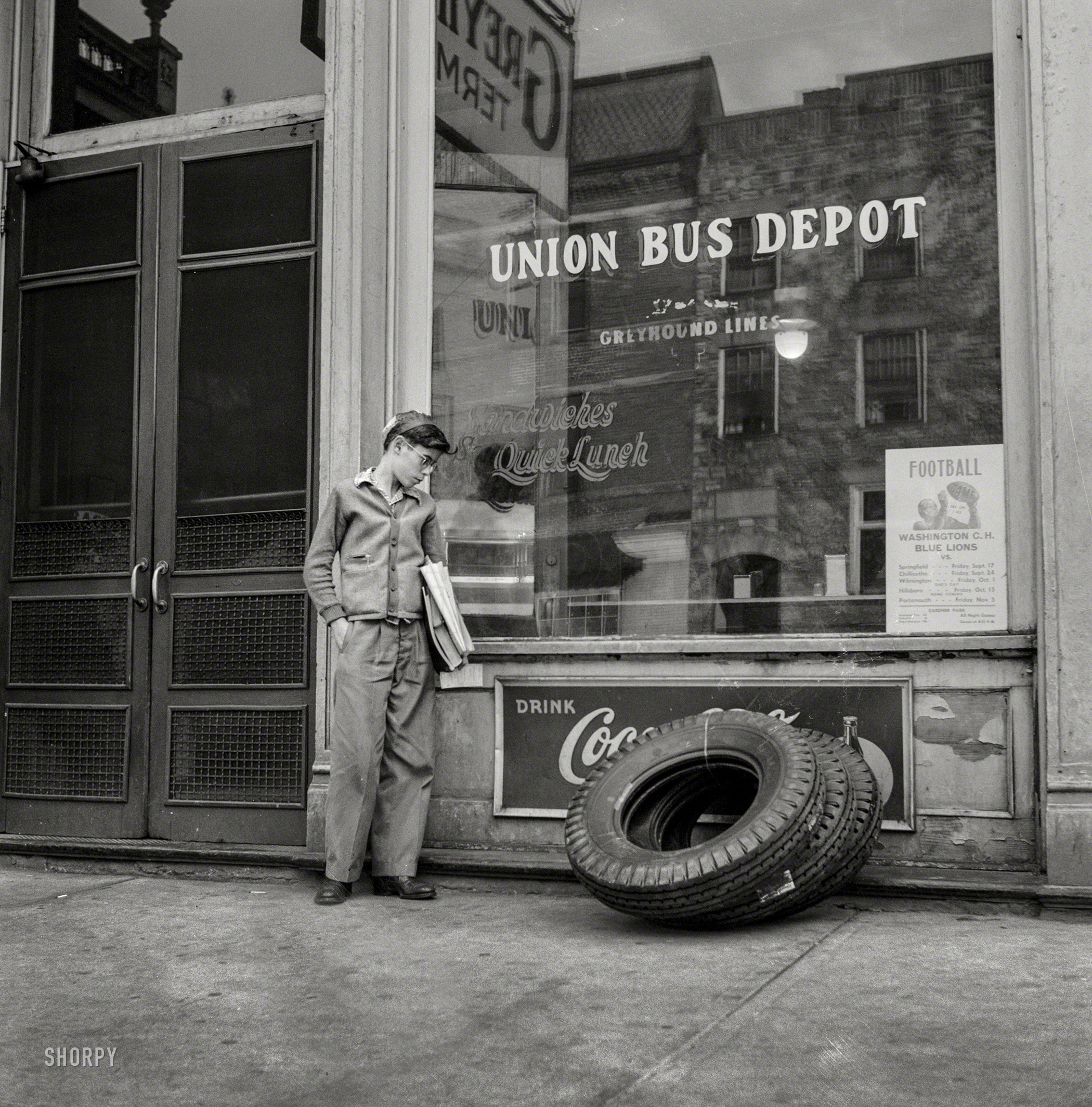 September 1943. Washington Court House, Ohio. "Boy who rides to and from school daily on a Greyhound bus waiting outside the depot." Medium format negative by Esther Bubley for the Office of War Information. View full size.