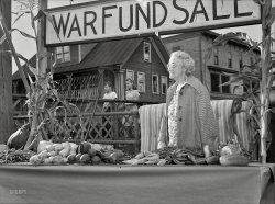 October 1942. Hardwick, Vermont. "Mrs. Alice White at the Victory Store vegetable counter selling donated farm produce, money from which will go to the War Fund." Photo by Albert Freeman, Office of War Information. View full size.
