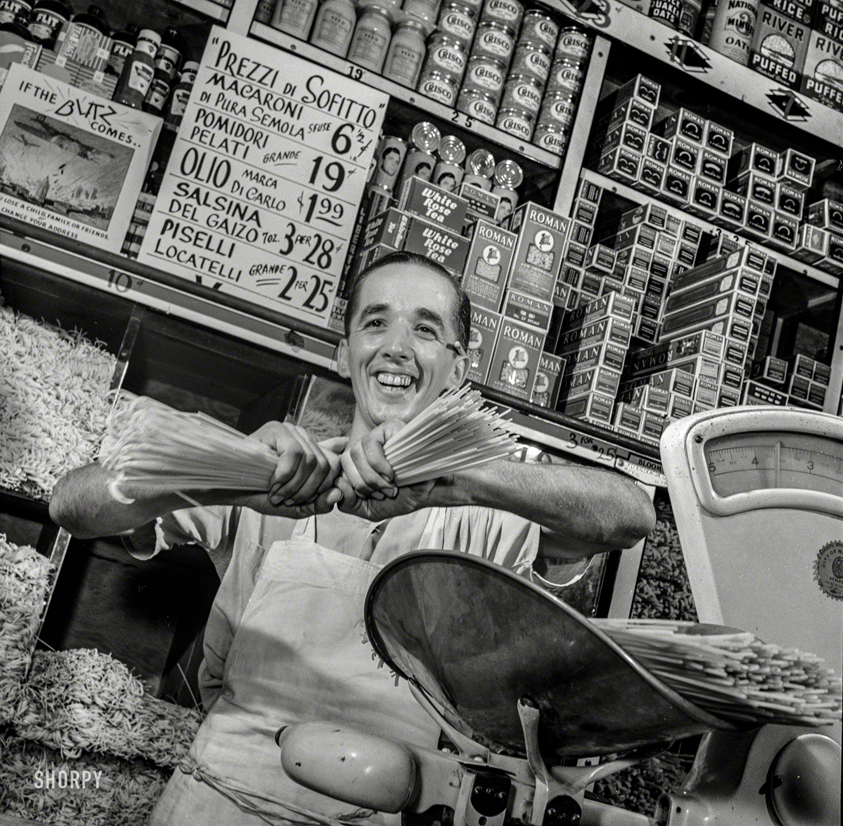 July 1942. "Posting ceiling prices in foreign languages. Charles Ruggiero, clerk in a grocery store in New York's Italian section, wishes the handful of spaghetti he is breaking were Mussolini's neck. The ceiling price sign above his head, written in Italian, is helping to defeat Il Duce by controlling inflation, one of America's most dangerous enemies." Medium format negative by Howard Liberman for the Office of War Information. View full size.