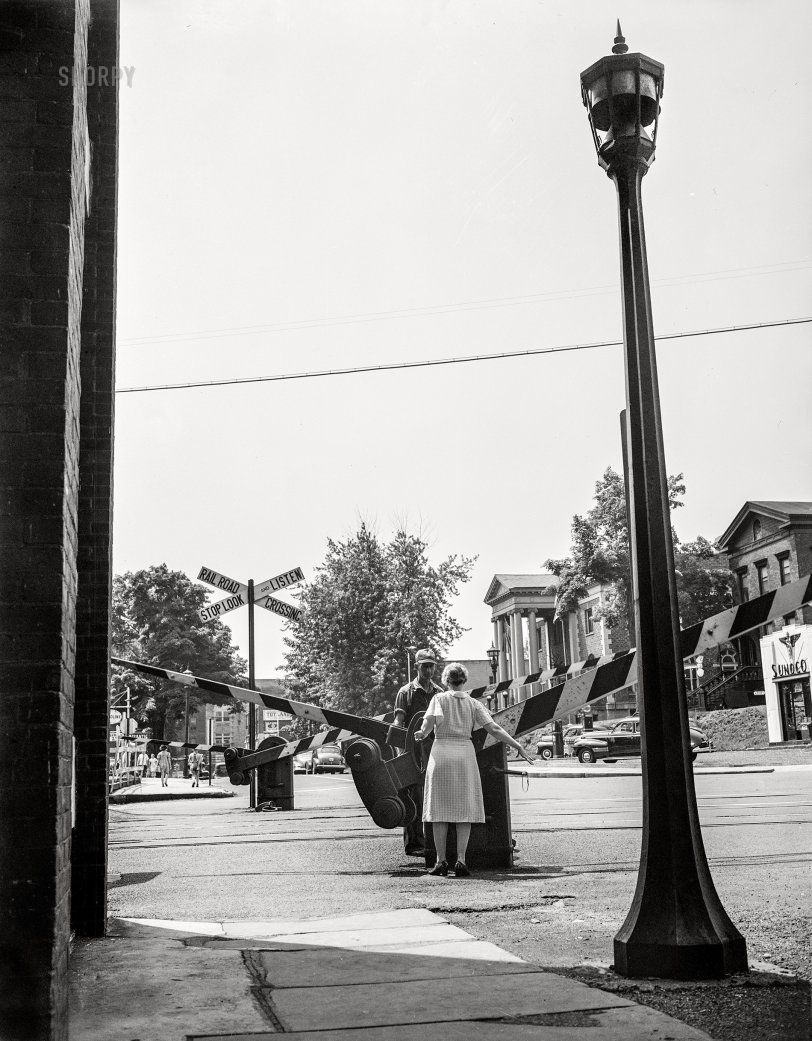 June 1943. "New Britain, Connecticut, is home to many essential war industries. A woman railroad crossing watcher letting down the gates until the train passes." 4x5 inch acetate negative by Gordon Parks for the Office of War Information. View full size.
