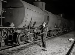 October 1942. "Tulsa, Oklahoma. Mid-Continent Petroleum Corp. refinery, Tulsa station of the Great Lakes pipeline. Armed railroad guard inspecting an oil tank car in the yards." Medium format acetate negative by John Vachon for the Office of War Information. View full size.
