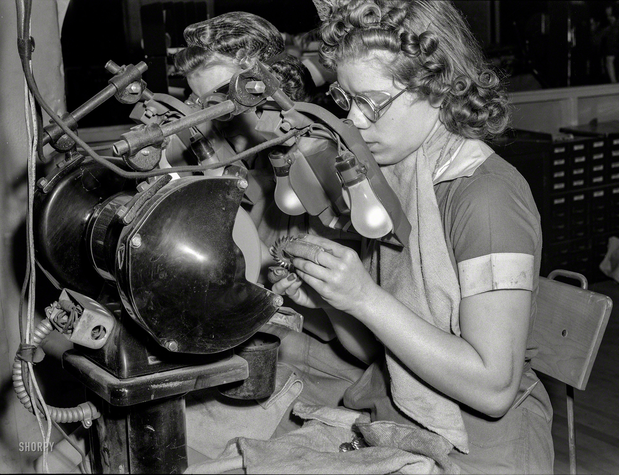 August 1942. "Women in industry. Sharp eyes and agile fingers make these young women ideal machine operators. They're conditioning and reshaping milling cutters in a huge Midwest machine tool company. Republic Drill and Tool, Chicago." Photo by Ann Rosener, Office of War Information. View full size.