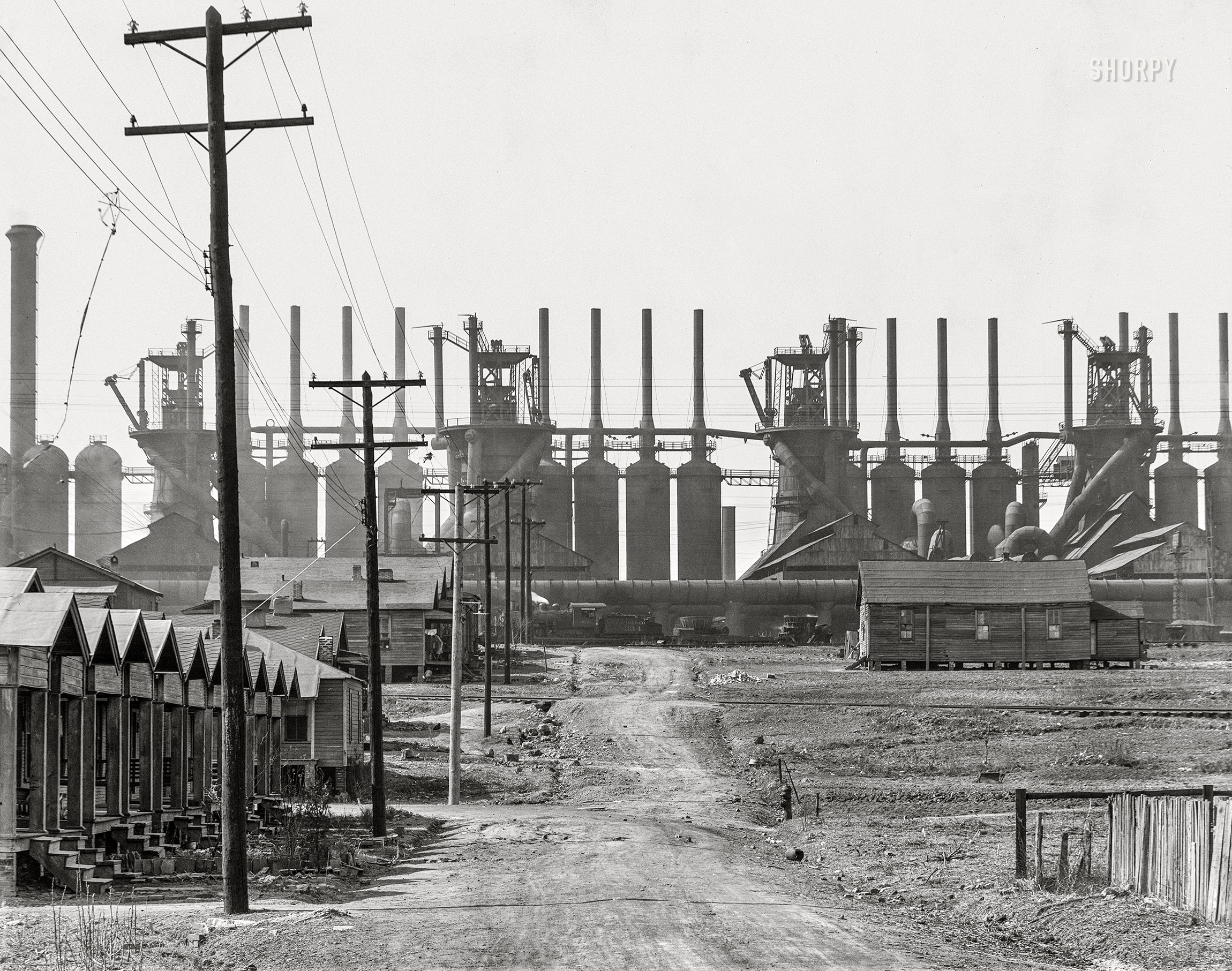 March 1936. "Steel mill and company houses -- Birmingham, Alabama." The Ensley works of the Tennessee Coal, Iron & Railroad Company, along with the skeleton of a snagged kite. 8x10 inch nitrate negative by Walker Evans for the U.S. Resettlement Administration. View full size.