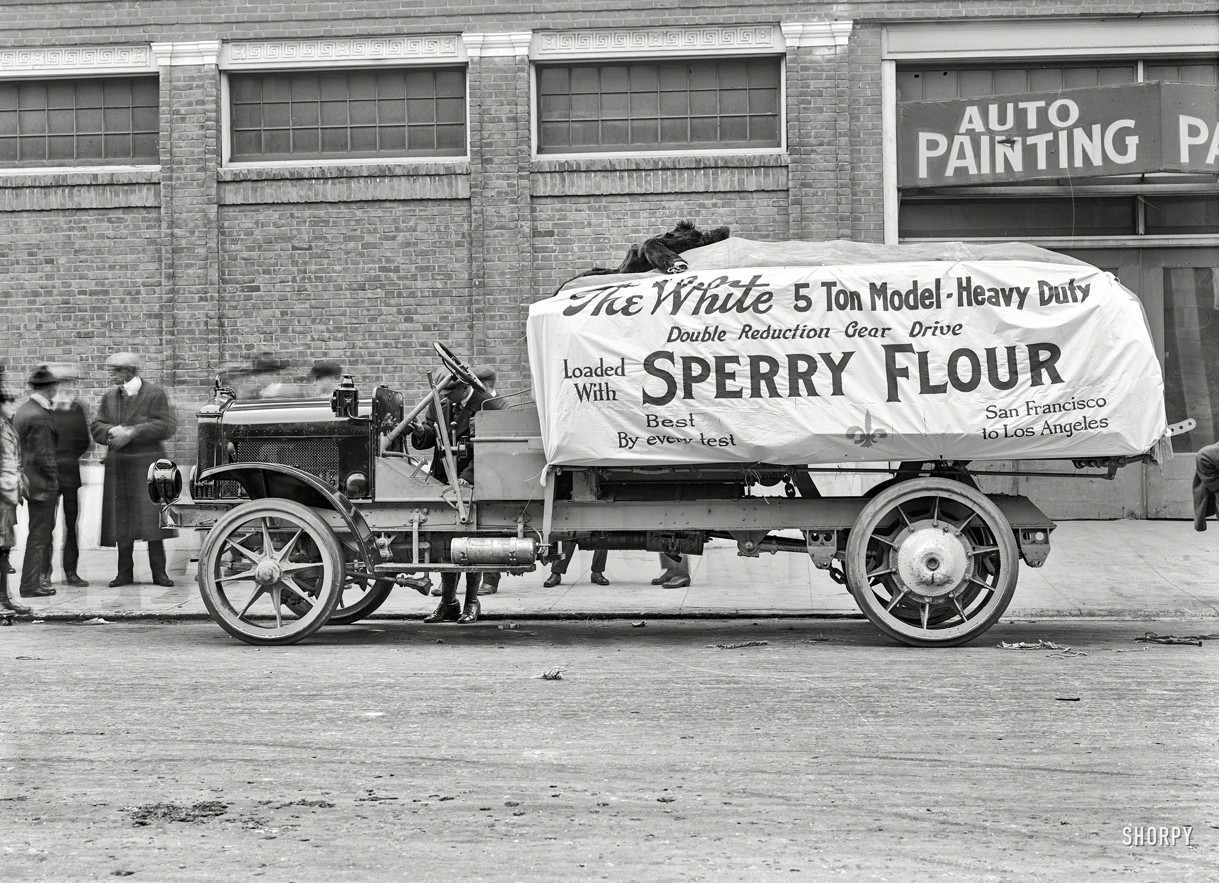 San Francisco circa 1918. "White 5-ton motor truck loaded with Sperry Flour bound for Los Angeles." Guarded by what looks to be a prototype version of the Cookie Monster. 5x7 glass negative by Christopher Helin. View full size.