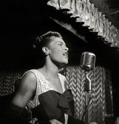 "Portrait of Billie Holiday at the Downbeat club, New York, ca. February 1947." Medium format negative by William Gottlieb. View full size.
&nbsp; &nbsp; &nbsp; &nbsp; I especially tried to capture personality, but that's an elusive quality, and I was successful only a portion of the time. But I certainly hit it on the button here with a picture of Billie Holiday, whose voice was filled with anguish. I also tried to catch the beauty of her face -- she was at her most beautiful at that particular time, which was not too long after she had come out of prison on a drug charge. She couldn't get at any drugs while she was incarcerated, or alcohol, and she lost weight and she came out looking gorgeous, and her voice was, I think, at its peak. And I was fortunate enough to have spent some time with her during that period, and I caught this close-up of her in a way that you could really see the anguish that must have been coming out of her throat.
-- William Gottlieb, 1997