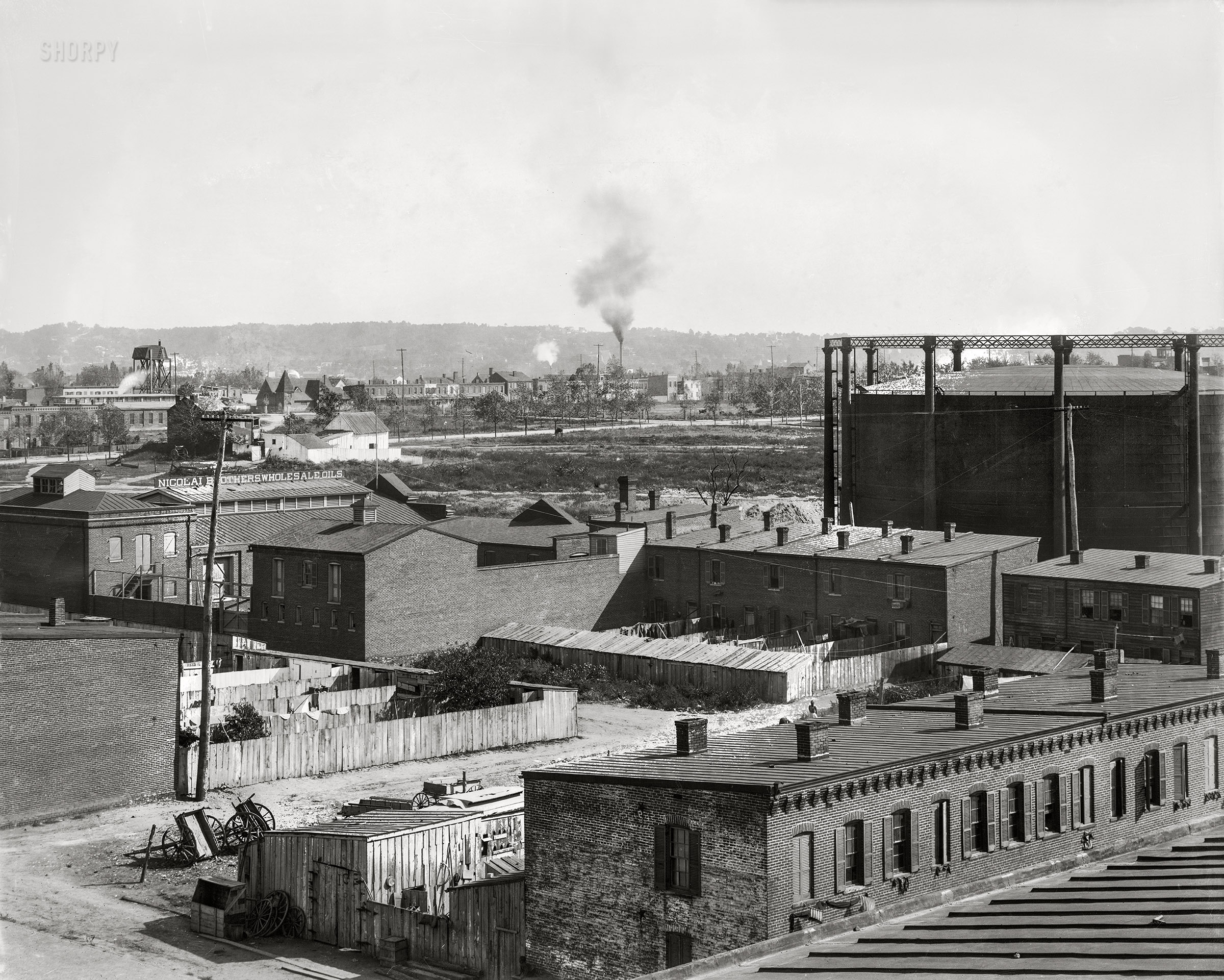 Washington, D.C., 1901. "Elevated view looking southeast from Randall Elementary School -- I Street at First Street S.W." Note the gas holder, or gasometer, at right; and black bunting or mourning crepe under the rowhouse windows, possibly in the aftermath of President McKinley's assassination. 8x10 glass negative, D.C. Street Survey Collection. View full size.