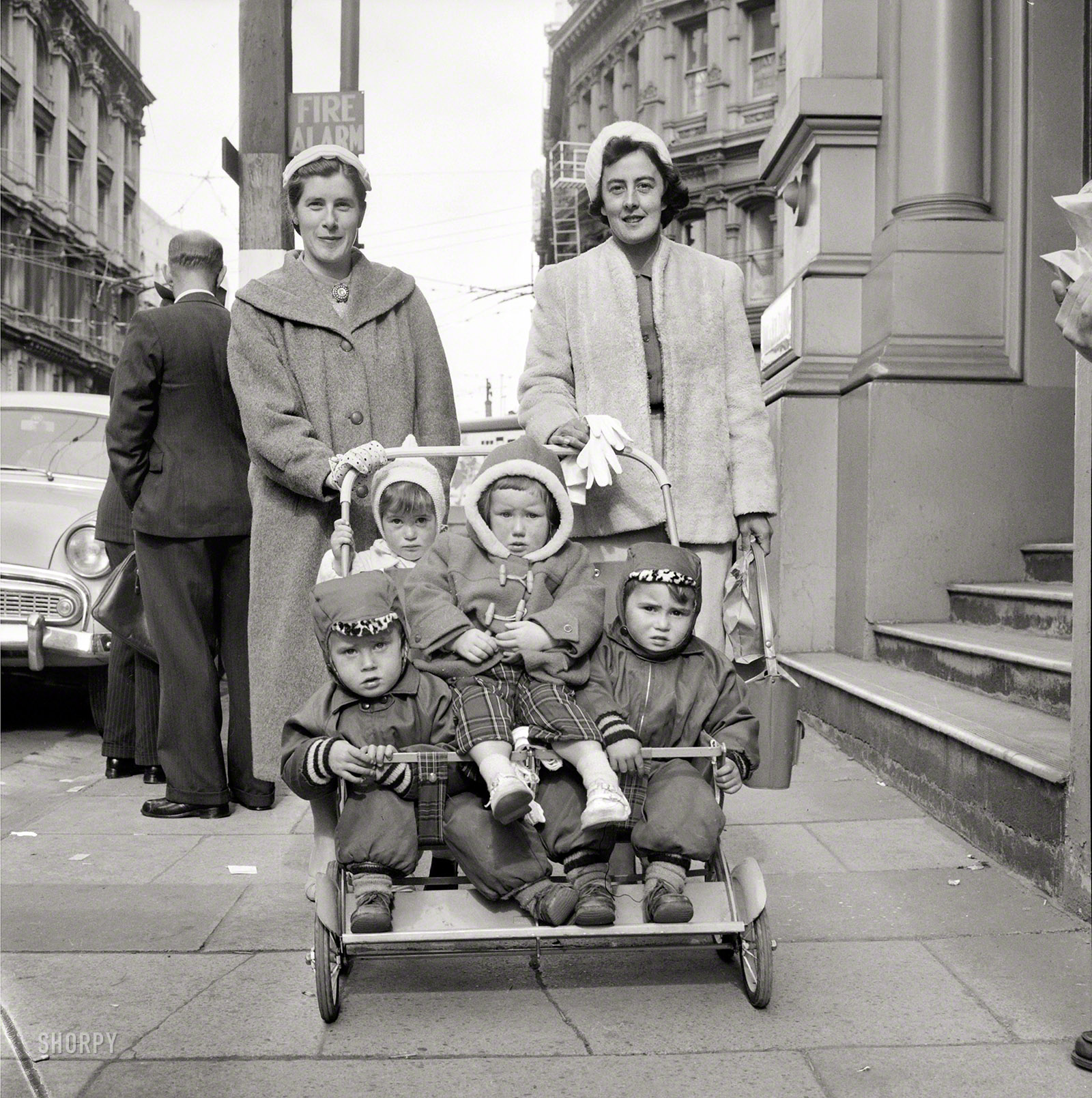 Aug. 21, 1959, somewhere in New Zealand. "Two women with four small children in a pushchair on a city street, probably Wellington." Evening Post newspaper photograph collection, Alexander Turnbull Library. View full size.