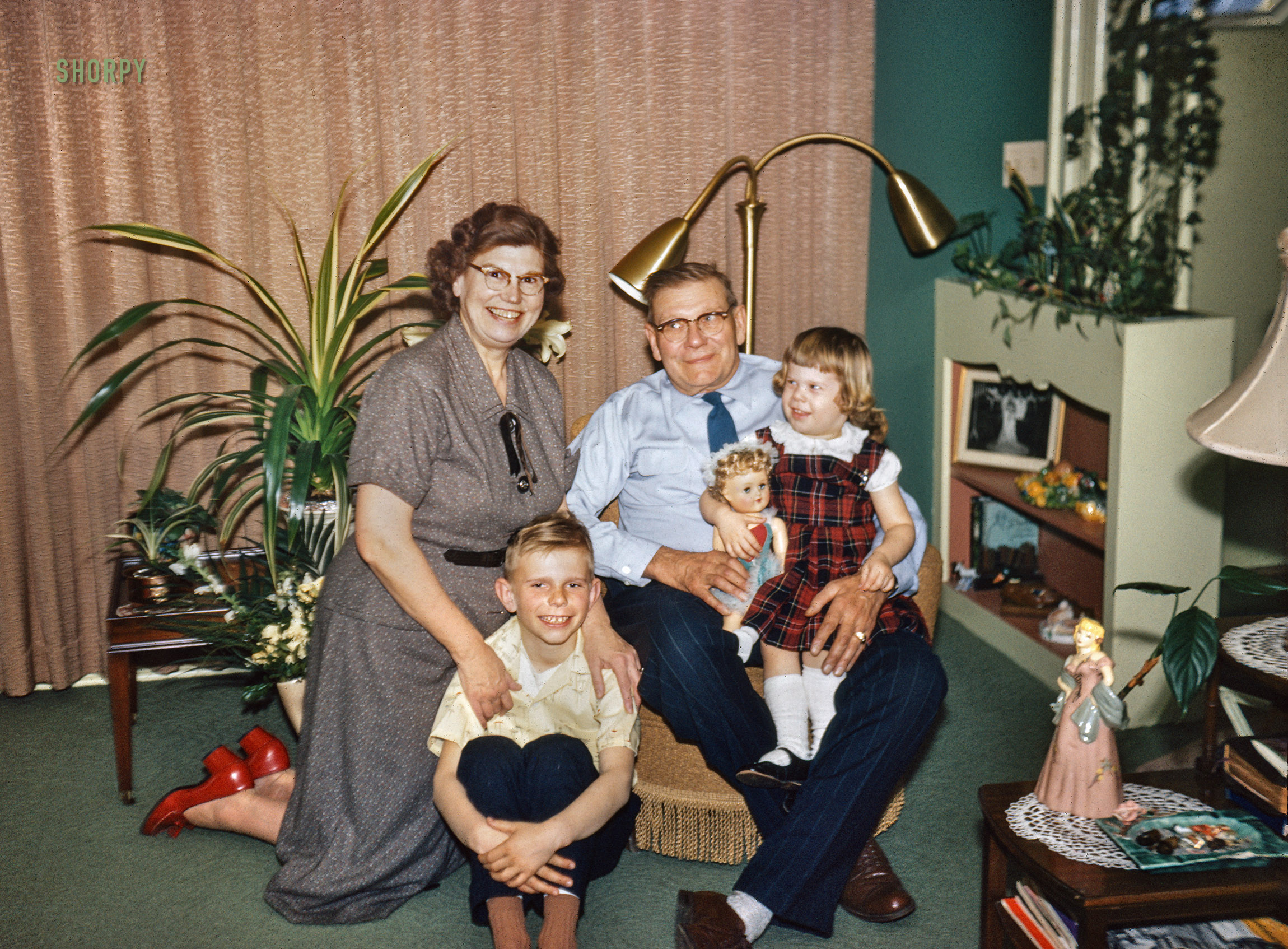 "Easter 1956." Mike and Barbara at their home in Menomonie with the grandparents, amid a polychrome plenitude of knickknacks and tchotchkes. View full size.