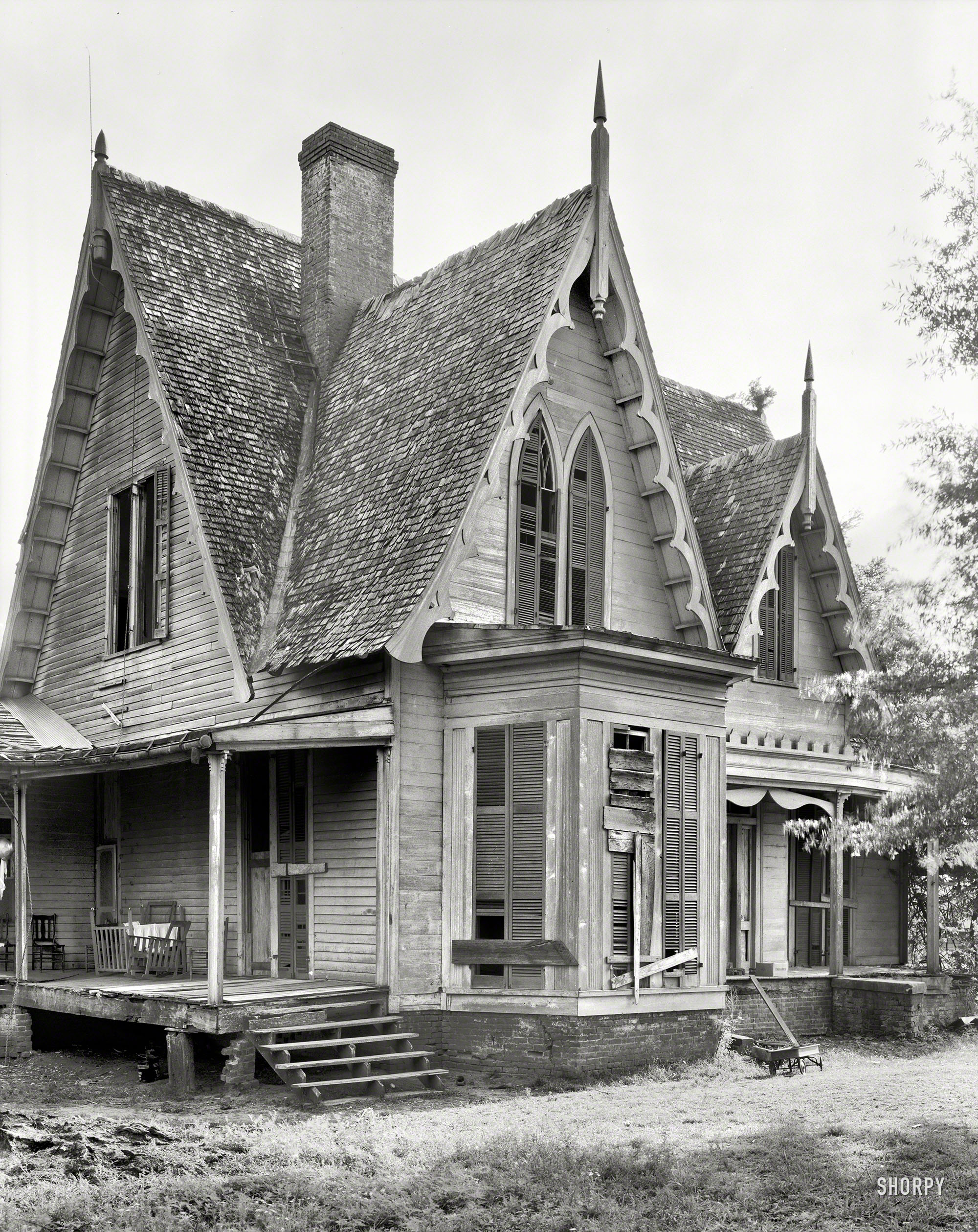 1939. "Knight House, Greensboro vicinity, Hale County, Alabama. Gothic Revival two-story frame built c. 1840." A little dilapidated, but it has good bones. Possibly under the porch. Photo by Frances Benjamin Johnston. View full size.