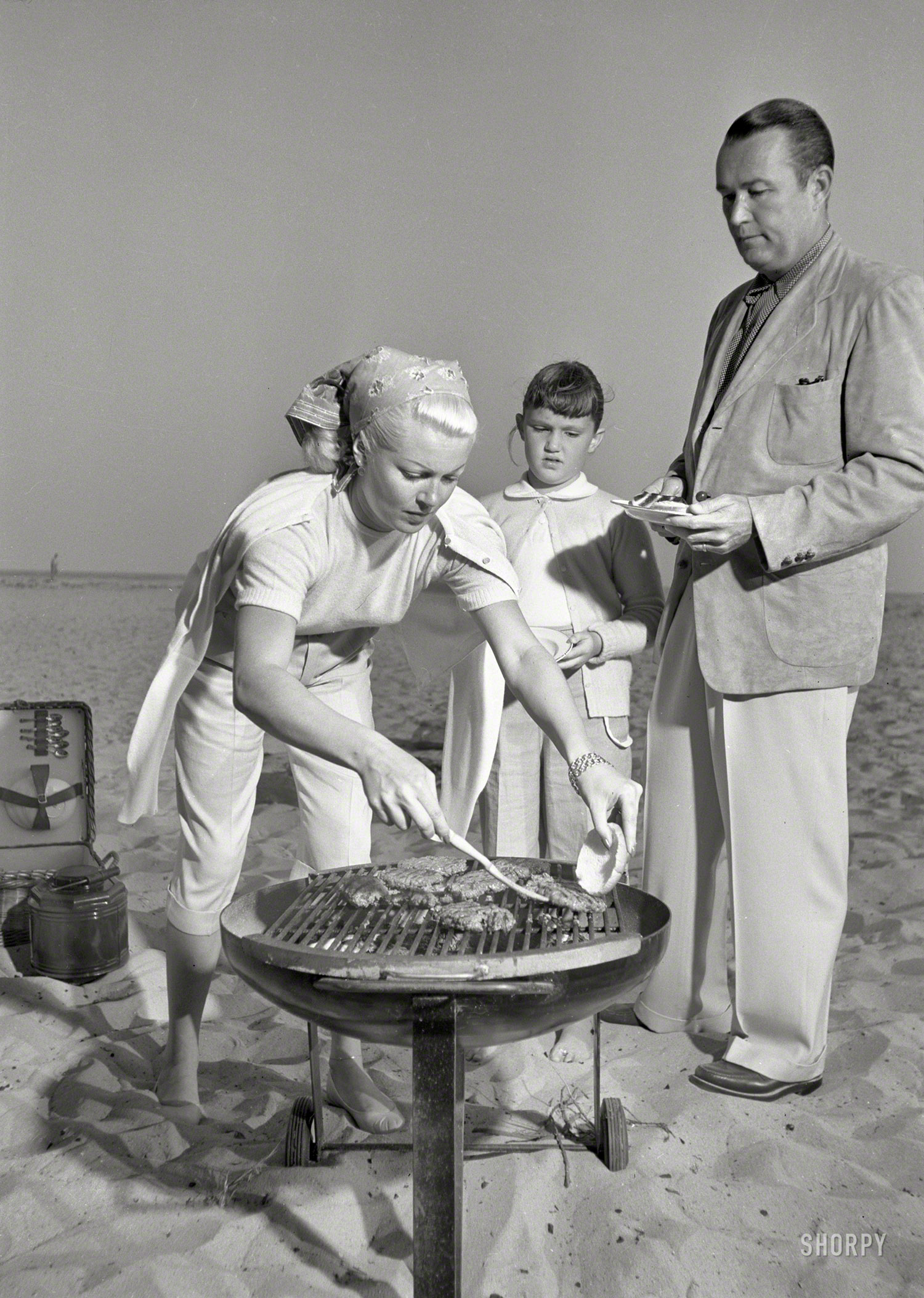 1951. Santa Barbara, Calif. "Actress Lana Turner, daughter Cheryl Crane and husband Henry J. 'Bob' Topping grilling hamburgers at beach." Carefree cookouts -- a family ritual! Photo by Earl Theisen for Look magazine. View full size.