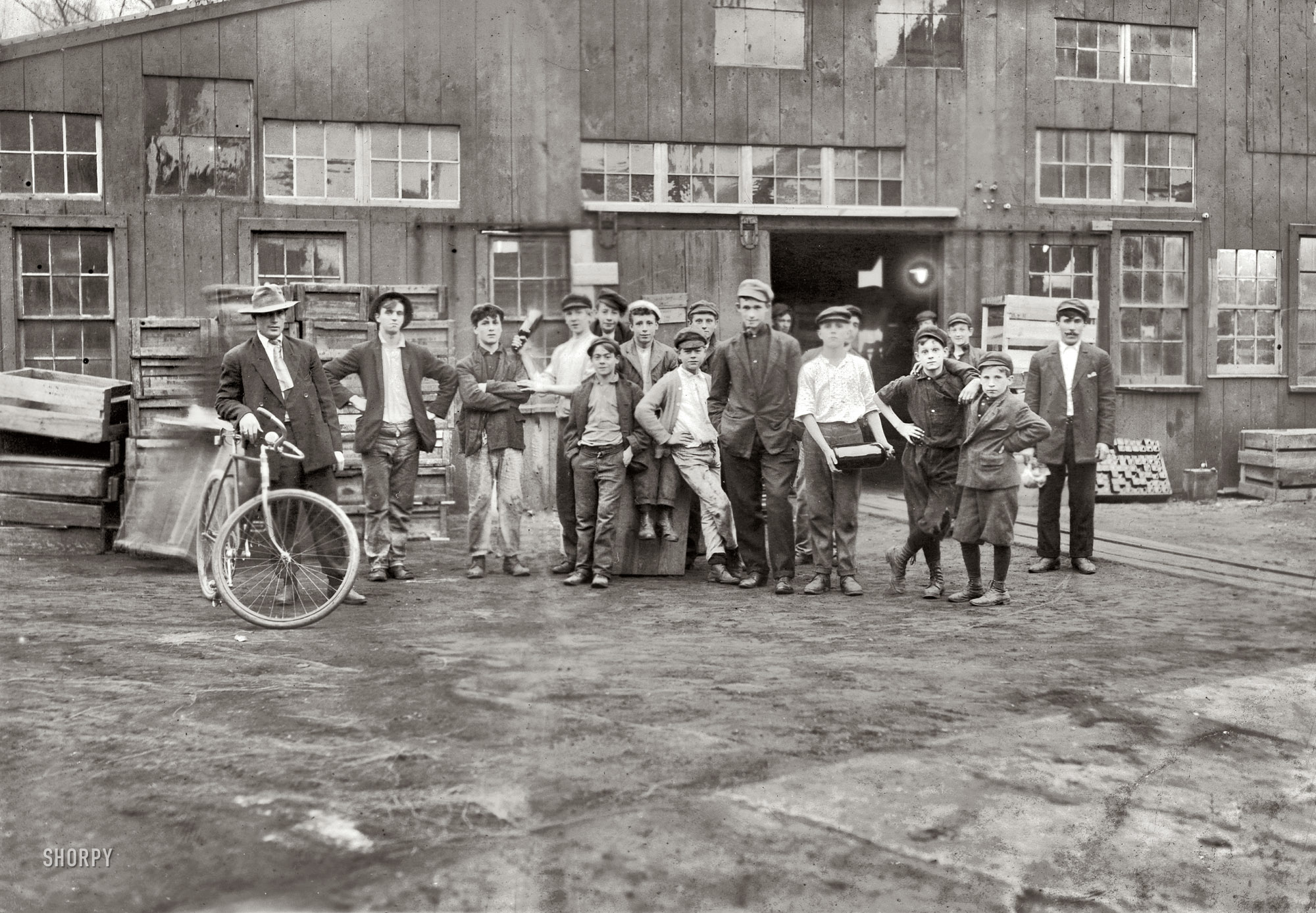 November 1909. "Some of night shift waiting to go to work. Cumberland Glass Works, Bridgeton, New Jersey. One boy is 13 years old." And then we have the operator on the left. Photograph by Lewis Wickes Hine. View full size.