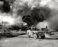 April 17, 1947. "Armed troops form a roadblock at Texas City, Texas, as all persons, including workers, were barred from entering the area where new explosions were expected. Fire in huge oil storage tanks burns in background." New York World-Telegram and the Sun Newspaper Collection. View full size.