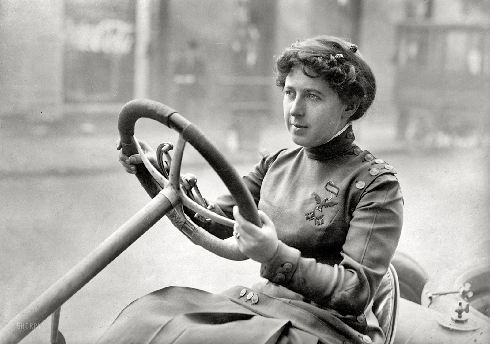 At the wheel circa 1915. "NO CAPTION" is the caption here. Perhaps someone will recognize the insignia on the lady's uniform. Harris & Ewing Collection glass negative. View full size.