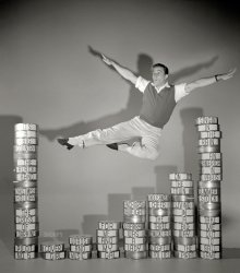 1952. "Entertainer Gene Kelly executing leap over film cans labeled with titles of his movies." From photos by Maurice Terrell for Look magazine. View full size.