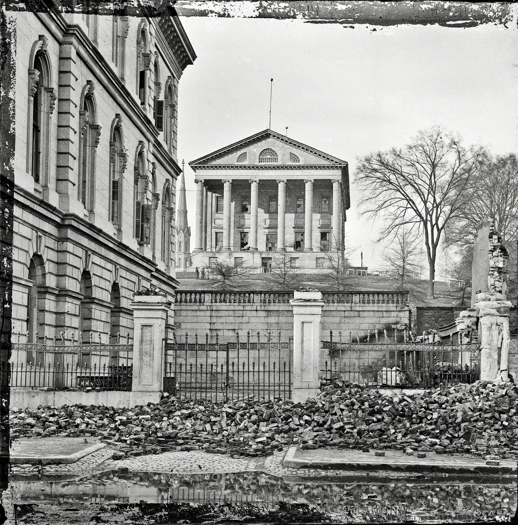 April 1865. "Fallen Richmond -- Custom House (left) and Virginia State Capitol; rubble in street." Wet plate glass negative. View full size.