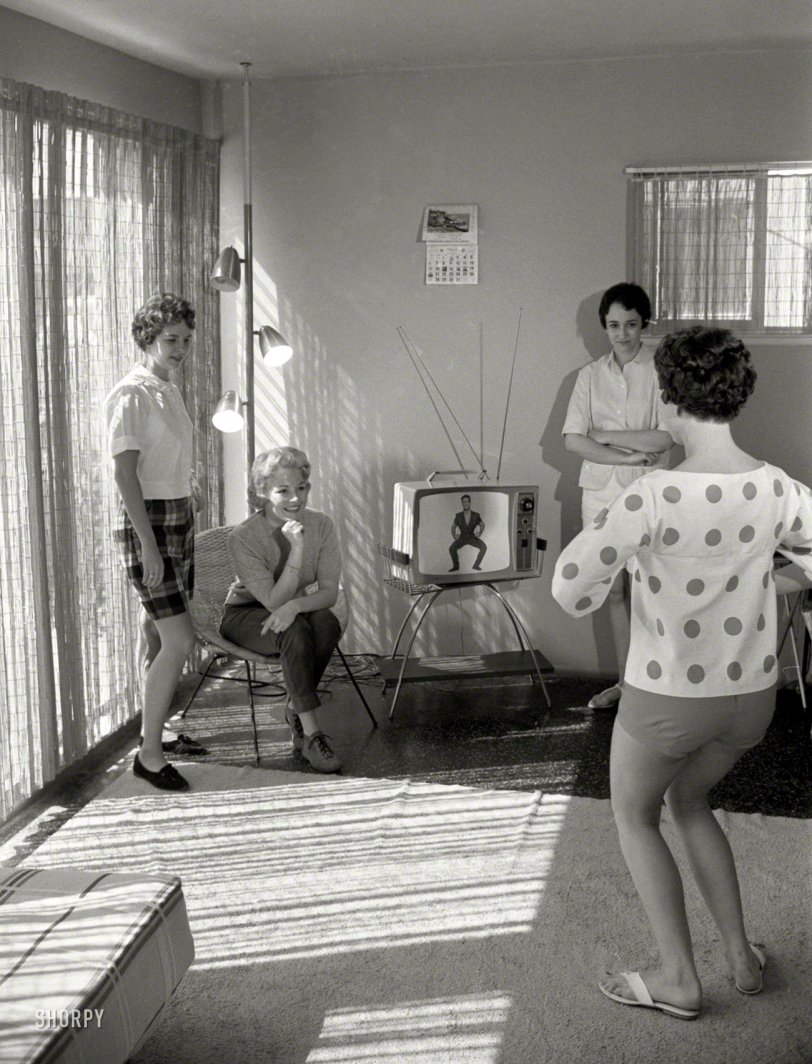 1960. "Airline hostesses Sue Pharris, Sharon Moore and two other women watching the Jack LaLanne physical fitness show and exercising." From photos taken to illustrate the Look magazine article "TV's Nature Boy." Among this picture's mid-century markers: Polka-dots, a pole lamp, rabbit ears, flip-flops, sliding glass doors. View full size.
