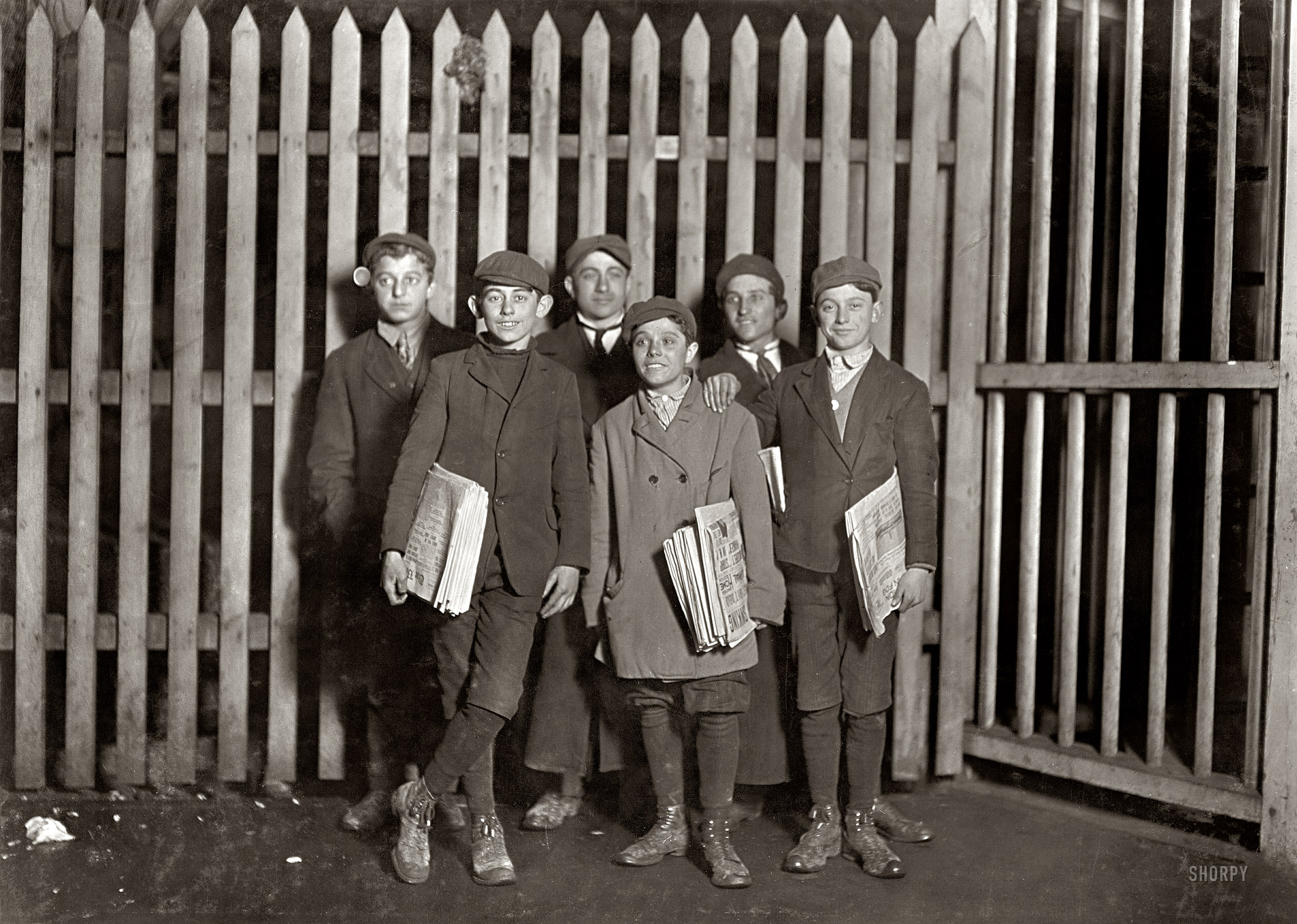 March 1909. Bridgeport, Connecticut. "7 P.M. -- Boys selling papers at the depot. Smallest one has been selling for eight years." The headlines: We see the words SINKING and IN FOG. Photograph by Lewis Wickes Hine. View full size.