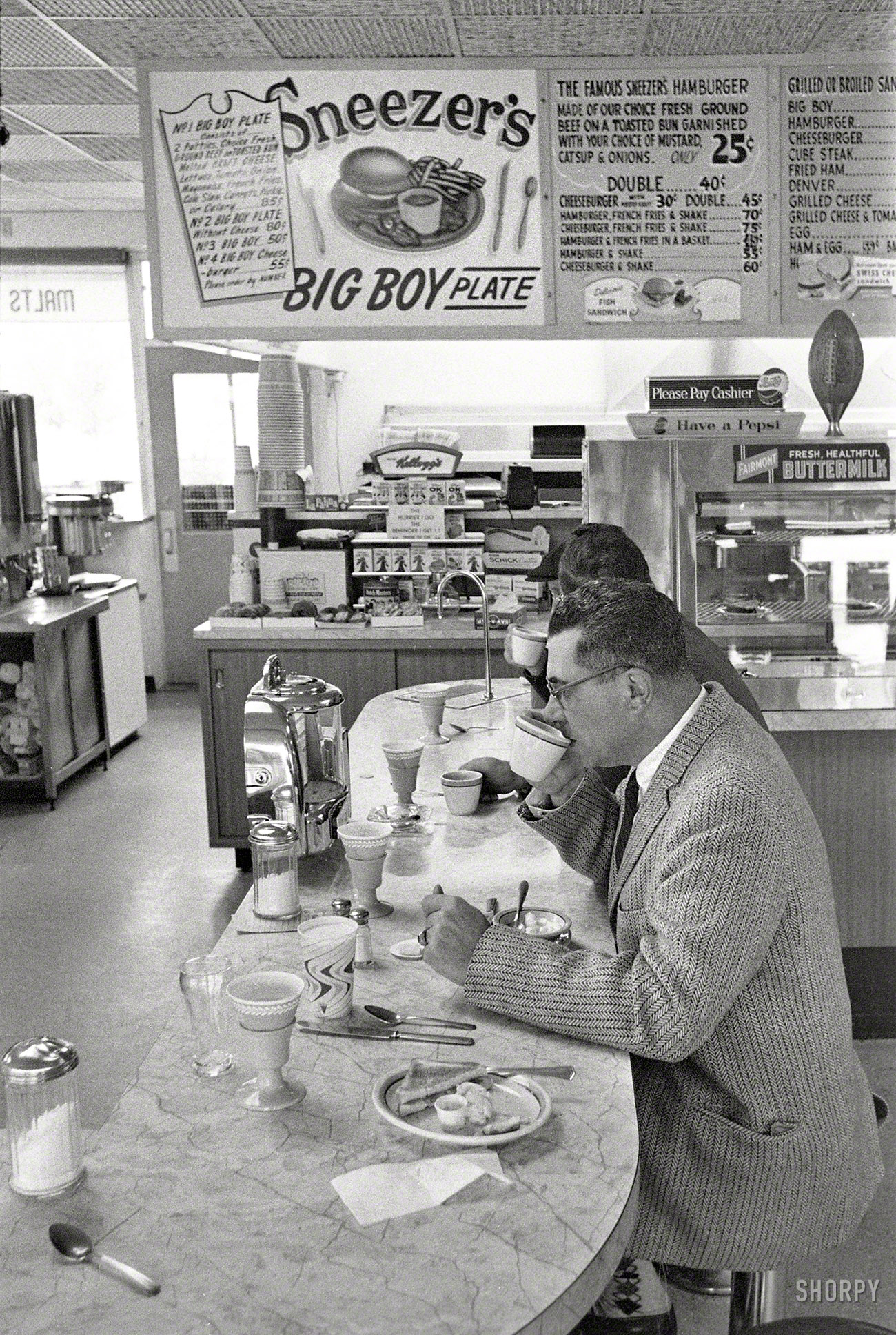 1960. Green Bay, Wisconsin. "Packers coach Vince Lombardi at lunch counter." Sneezer's No. 2 -- could anything sound more appetizing? Photo by Frank Bauman for the Look magazine assignment "The Packers Pay the Price." View full size.