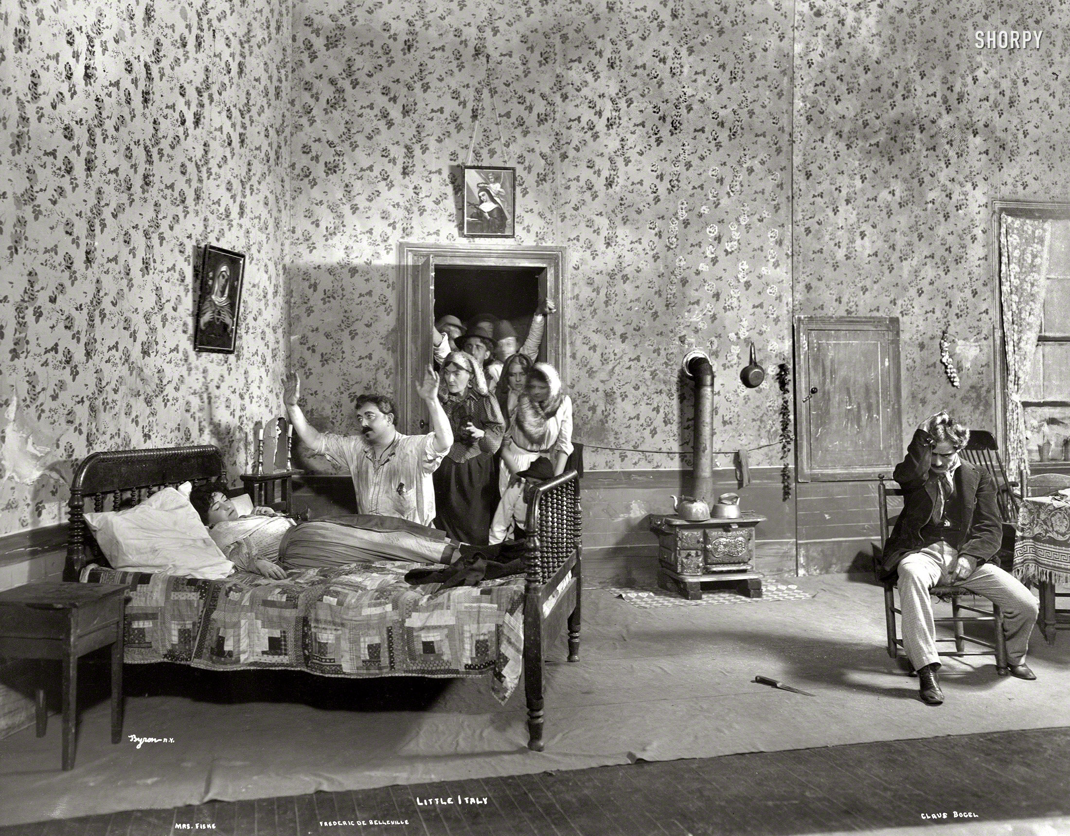 &nbsp; &nbsp; &nbsp; &nbsp; "Permeated by the passionate, vengeful Neapolitan spirit, despite a pleasing lack of half-intelligible broken English."
-- New York Times

New York, 1902. "Scene from Little Italy showing Minnie Maddern Fiske on bed, Frederic De Belleville kneeling, Claus Bogel seated with head bowed, and group of people in doorway." Little Italy, a "one-act tragedy of the East Side" by Horace Fry first performed in 1898, was revived on Broadway in 1902 for a 24-performance run at the Manhattan Theatre. Joseph Byron photo. View full size.