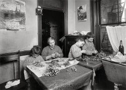 January 1912. New York. "Basso family, 2 Carmine Street, Apt 17. Making roses in dirty, poorly lighted kitchen. They work some at night. Pauline, 6 years old, works after school. Peter, 8, works until 8 p.m. Mike, (cross-eyed), 12 years old, until 10 p.m. Father keeps a rag shop." Photo by Lewis Wickes Hine. View full size.