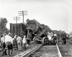 Laurel, Maryland. July 31, 1922. "Two B&amp;O freights wrecked in head-on crash at Laurel switch." National Photo Company glass negative. View full size.
CREWS ESCAPE BY JUMPINGWashington Post, August 1, 1922.


2 FREIGHTS CRASH
AT LAUREL SWITCH
Both Engines and 4 Cars
Demolished When B&amp;O Trains
Meet in Head-On Collision.
CREWS ESCAPE BY JUMPING
Leg of Engineer Ramsey Broken,
50 Yards of Track Torn Up,
Tie-Up Lasts Hours.
&nbsp; &nbsp; &nbsp; &nbsp; Six men narrowly escaped death yesterday afternoon when two freight trains of the Baltimore and Ohio Railroad Company crashed in a head-on collision near Laurel, Md. David Ramsey, one of the engineers, was taken to a Baltimore hospital suffering from a broken leg. The others escaped injury by jumping just before the crash.
&nbsp; &nbsp; &nbsp; &nbsp; Both engines and four freight cars were demolished and the passenger and freight service of the railroad company was tied up for several hours while wrecking crews removed the debris. Commuters between Washington and Baltimore who were unable to obtain a lift from passing automobiles were forced to walk to their destination.
Meet at Open Switch.
&nbsp; &nbsp; &nbsp; &nbsp; The accident occurred at a crossways near Laurel, where the east and westbound freights met in an open switch. The train crews had hardly jumped to the ground when the heavily loaded freight cars crashed into one another, the eastbound engine being hurled 25 feet in the air.
&nbsp; &nbsp; &nbsp; &nbsp; Wrecking crews were quickly sent to the scene, and emergency telephone connections established with the train dispatcher's office at Baltimore.
Passenger Trains Diverted.
&nbsp; &nbsp; &nbsp; &nbsp; Passenger trains of the Baltimore and Ohio were sent out over the tracks of the Pennsylvania road to Overton, Md., then to the main line of the Baltimore and Ohio.
&nbsp; &nbsp; &nbsp; &nbsp; Officials of the railroad at the scene of the wreck refused to place responsibility for the accident, and busied themselves at once to clear away and repair the 50 yards of track torn up by the collision.
Grand Funk RailroadPics like this always remind me of those 70's album covers.
The term"my bad" was coined at that very moment.
I do believeThat this situation was called a ‘’cornfield meet.’’
The great train wreckThe most interesting aspect of the wreck, to me, is the way it was covered in the local newspaper, the Laurel Leader.
Not at all.
The next issue after the accident, on 8/04/22, included front page stories of a collision of two ships near Seattle and the arrest on murder charges of a number of Prohibition agents in Texas, but nary a word on an accident in the back yard.  The paper seems, back in the day, to have had almost no local reporting presence, relying on wire services and pre-packaged feature material.  (It has much more local focus today, even though it's now published in nearby Columbia.)
Even more oddly, perhaps, I don't find any mention of the wreck in the Baltimore Sun (published, after all, in the B&amp;O's home town).
(The Gallery, D.C., Natl Photo, Railroads)
