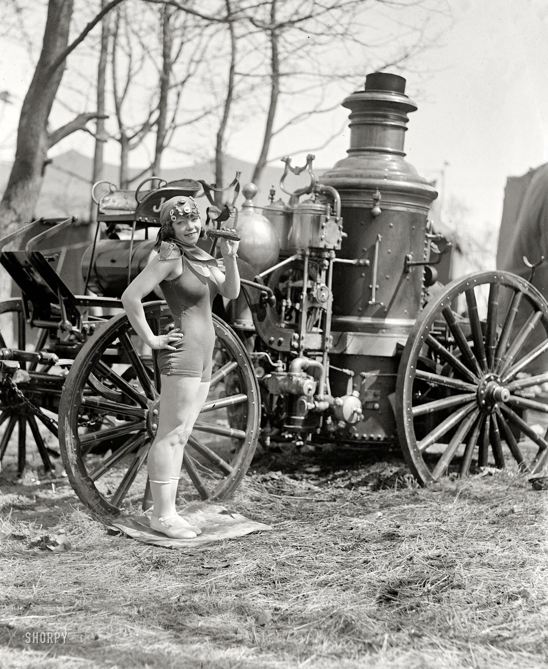 "Beatrice Kyle, in high diving outfit, between acts at the Society Circus at Fort Myer, Virginia, for the benefit of the Army Relief Fund, April 25, 1924." In what looks like a marketing tie-in for carny food and old fire engines. View full size.