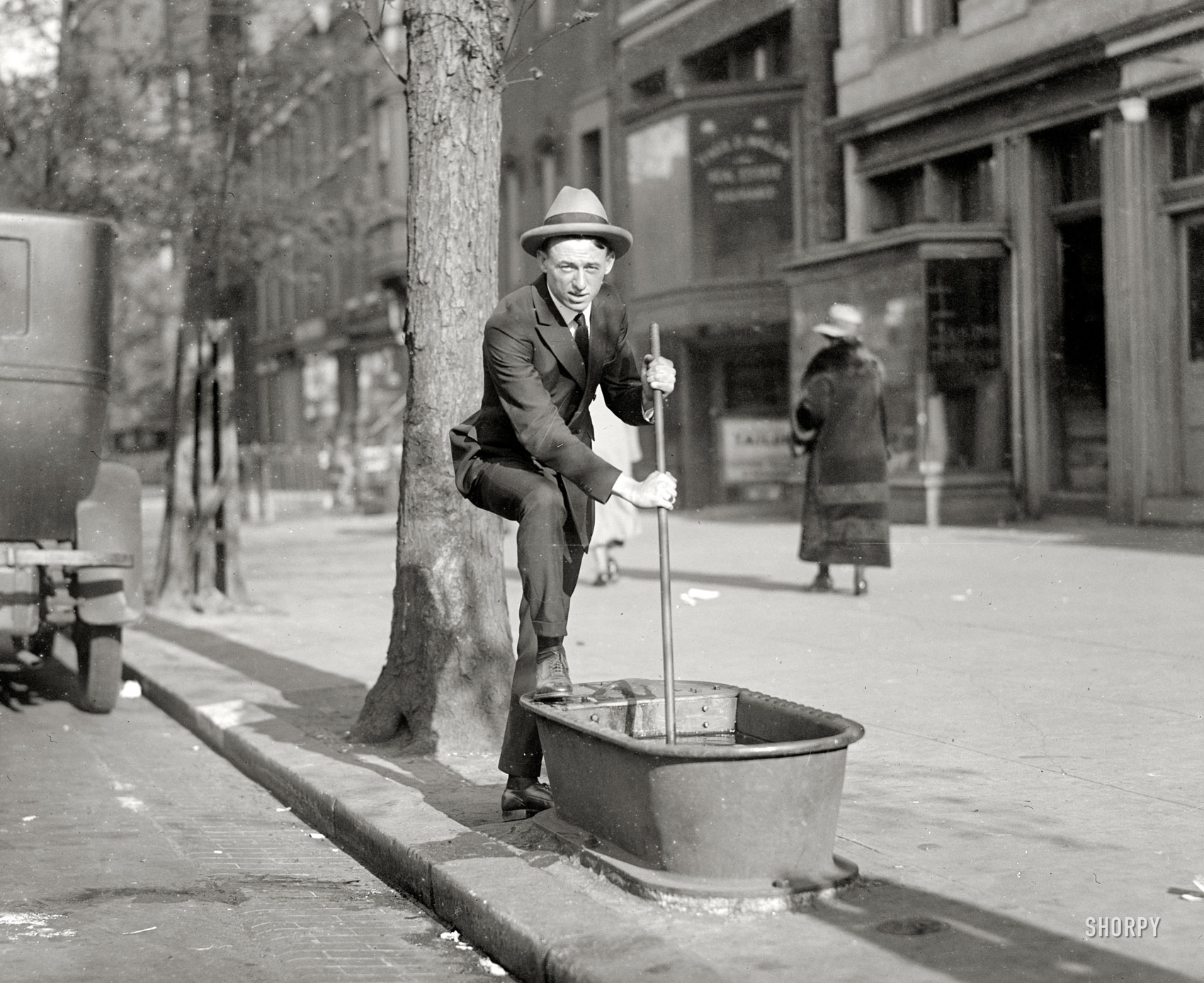 Washington Post staff photographer Hugh Miller in 1924, clowning with an item that, along with lampposts and mailboxes, used to be common piece of urban street furniture: the sidewalk horse-waterer. National Photo Co. View full size.