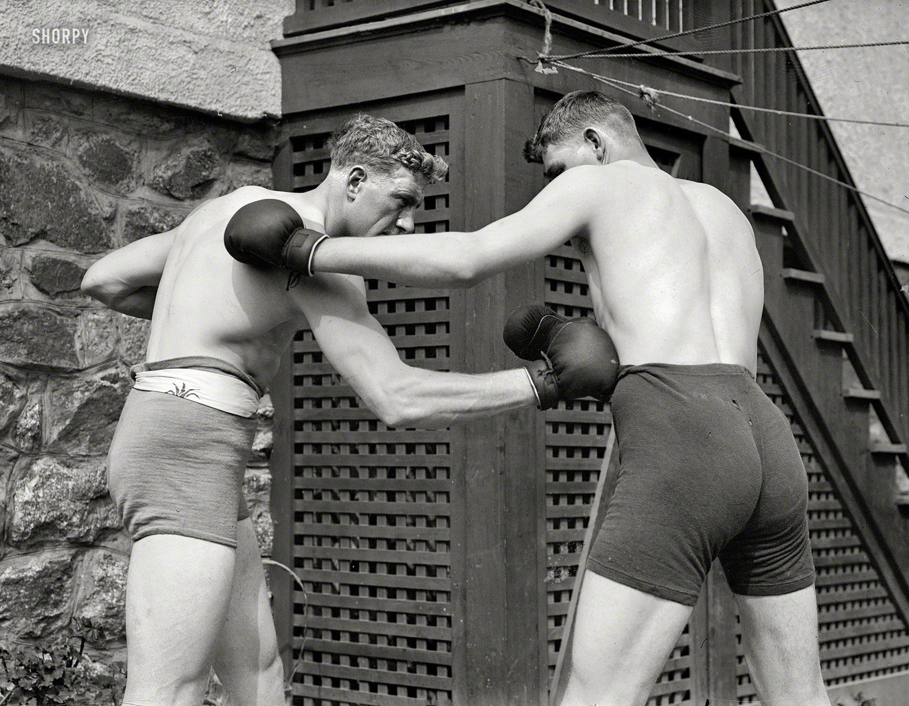 June 27, 1912. Rye, New York. "Wells & Coffey." English heavyweight champion "Bombardier" Billy Wells, left, sparring with Jim Coffey, the Roscommon Giant, to prepare for his fight with Al Palzer. Palzer won by a knockout in the third round. 5x7 glass negative, George Grantham Bain Collection. View full size.