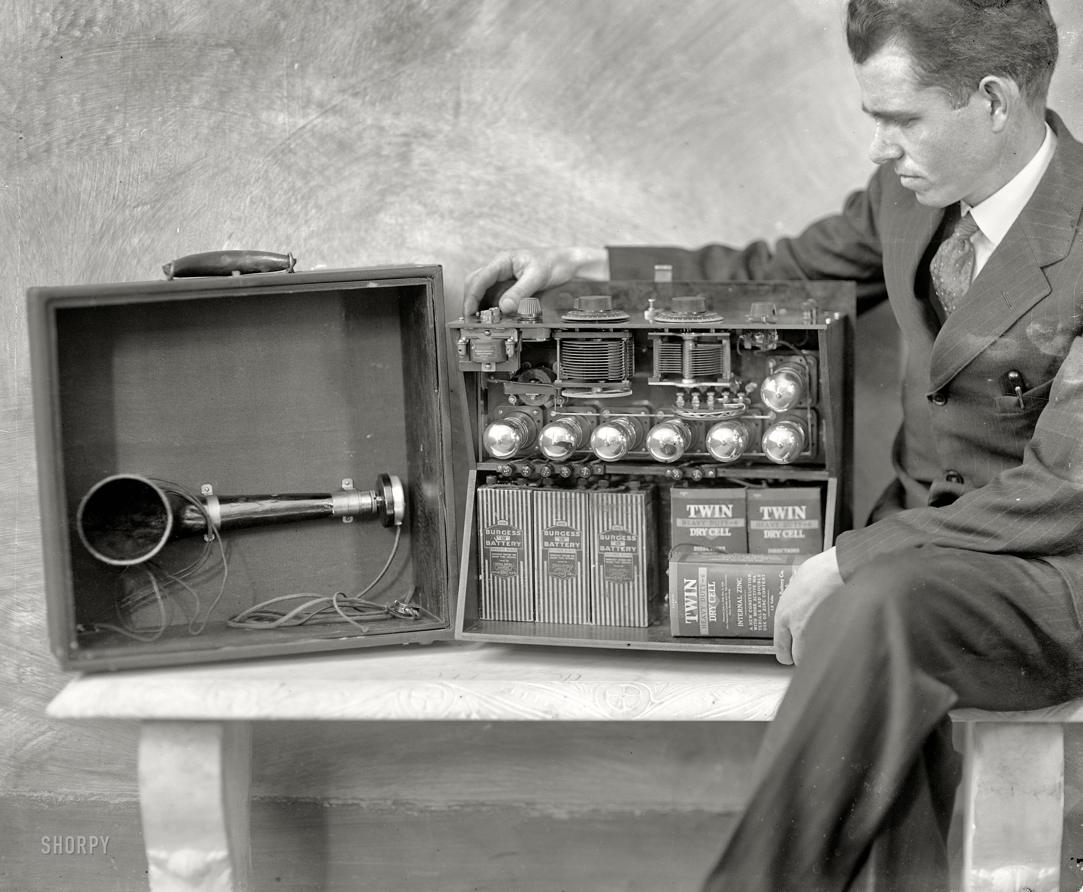Washington, D.C., circa 1924. "Brent Daniel, formerly of the Radio Laboratory of the Bureau of Standards at Washington, with the first portable Super-Heterodyne, his own design. The seven vacuum tubes, batteries, loop antenna, loudspeaker and other necessary units are completely self-contained in the carrying case. He has been able to hear Pacific Coast stations from this outfit." View full size.