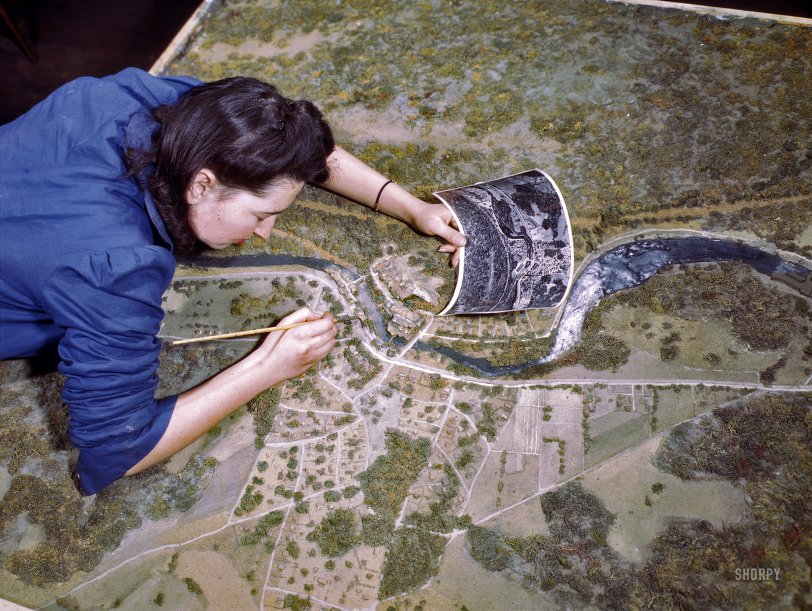 March 1943. "Camouflage class at New York University, where men and women are preparing for jobs in the Army or in industry. This model has been camouflaged and photographed. The girl is correcting oversights detected in the camouflaging of a model defense plant." 4x5 Kodachrome transparency by Marjory Collins for the Office of War Information. View full size.
