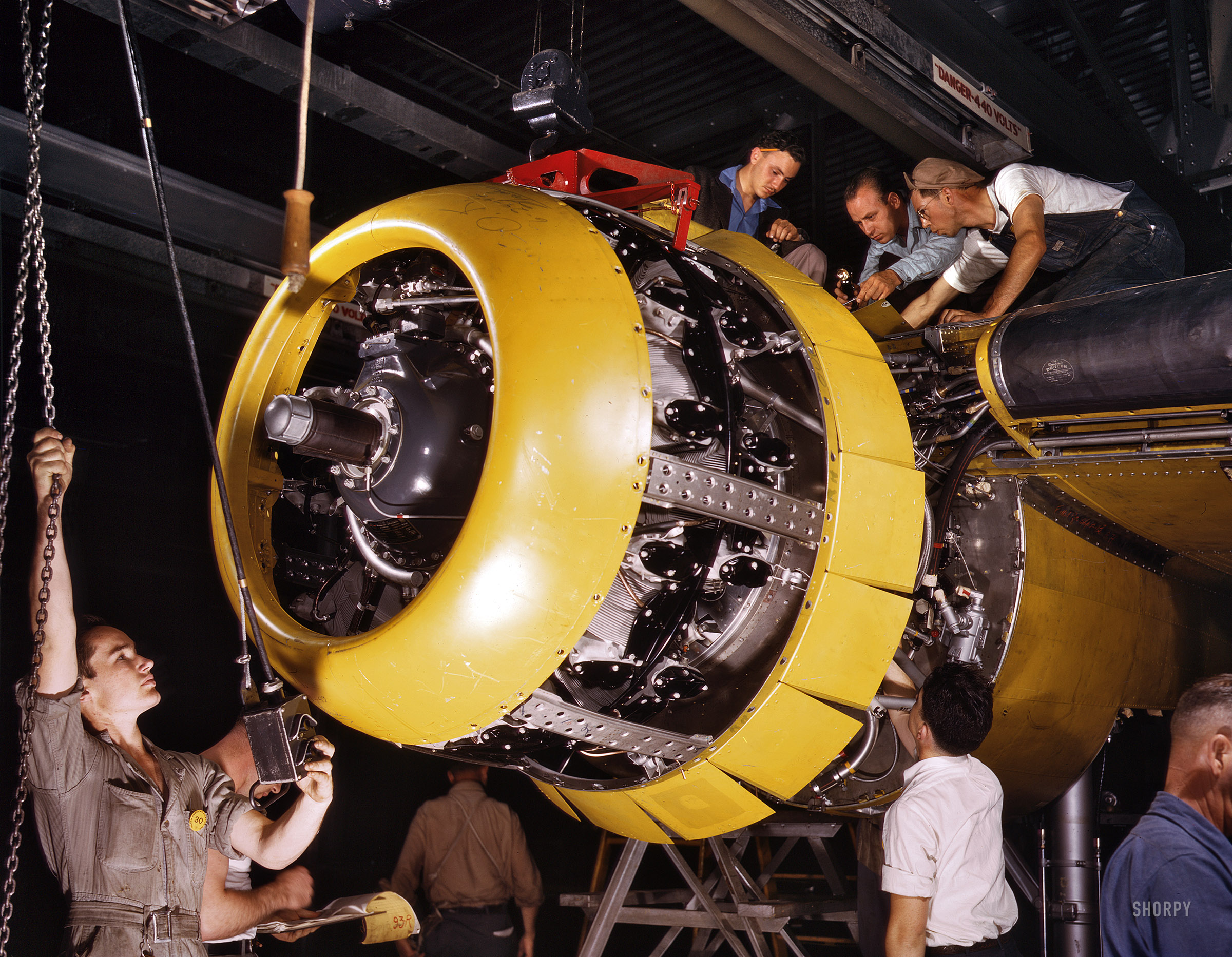 July 1942. "Production. B-25 bombers. Mounting a 1700-horsepower Wright Whirlwind engine to the firewall of a B-25 bomber. Fairfax bomber plant, Kansas City." 4x5 Kodachrome transparency by Alfred Palmer. View full size.