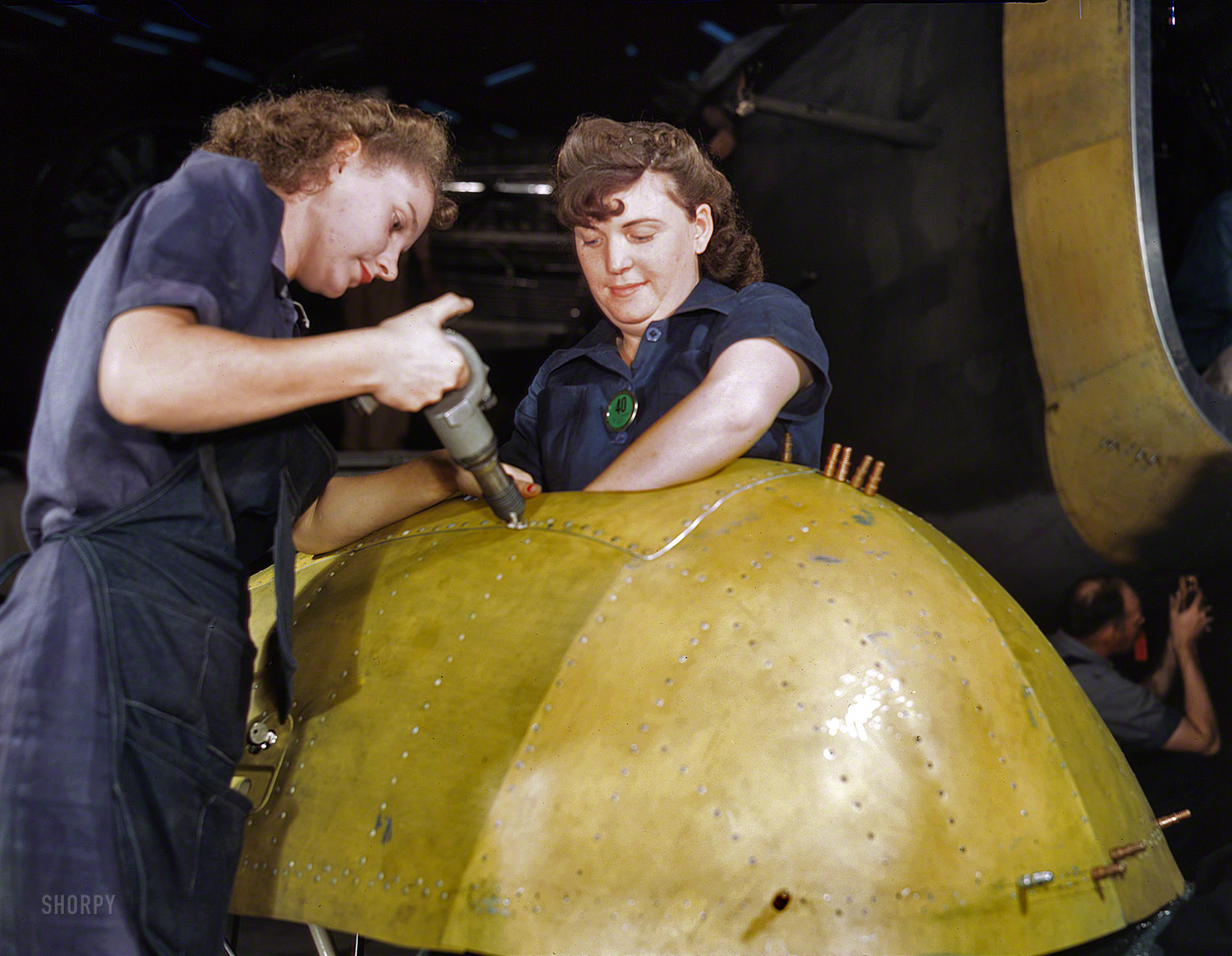 February 1943. "Working on a 'Vengeance' dive bomber at Vultee Aircraft in Nashville, Tennessee." Gunning away at the Axis, one rivet at a time. Kodachrome transparency by Alfred Palmer, Office of War Information. View full size.