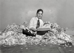 Nov. 30, 1920. Washington, D.C. "Charles M. Schwab, of the Kalorama Apartments, probably has the largest collection of stamps in the East. This is a pile of approximately two million." National Photo glass negative. View full size.
Hey look at this!I would wager that posing him this way was the photographer's idea. I once saw a newspaper photographer talk two boys into posing INSIDE a huge pile of leaves they had raked up. The photo got published.
RelationsThis is not the nephew of steel magnate Charles Michael Schwab. The kid appears to be the son of Frederick and Molly Schwab. In 1930, age 21, he was still living at home and working as a bookkeeper. But you coulda guessed that.
Stamp accumulationA thin line separates collecting from accumulating. I think this kids just crossed that line. 90% of the stamps piled here are from the Franklin (1cent) /  Washington (3cent)  series which where the common stamps of the day at that time and are worthless (with some exceptions) today. Because most of the stamps are still attached to the envelop paper they were sent on, I can make an educated guess that this kid's father worked in a big office and brought home all of these stamps for him.
[Speaking as a fellow sometime-philatelist, I'd say the album indicates he also has a real stamp collection. -tterrace]
Charles Schwab? Did getting go on to found a brokerage firm? Or was that his son?
[No relation. -tterrace]
But:Is this not a rather odd way to display your collection, valuable or not?
Nephew of American steel magnate?Charles Michael Schwab (1862-1939) was an American steel magnate. Not related to the founder of the brokerage firm Charles Schwab Corporation
He had a namesake nephew, the son of his brother Joseph. Could this be who this is? This boy certainly has the elder Charles Michael Schwab ears.   
Stamp Collecting DazeI started collecting stamps around 1957, when I was ten, when my parents bought me an orange cloth bag of foreign stamps from the local 5 &amp; 10 store for a dollar. The stamps were still on the envelope paper like Chuck's. You had to soak them off with water. Lots of duplicate general postage stamps from the UK. My grade school collected US postage stamps and sent them to a company which bagged them up for sale overseas.  Some of the girls in my class sorted these stamps and gave me the foreign stamps which the company did not want.  One time I was given a large amount of foreign stamps which someone had taken out of a stamp collection and donated to the school. What a treasure trove that was. My Aunt from New York worked in an office which received a large amount of foreign correspondence.  She would save up the stamps and mail them to me. One of my boyhood friends had a grandfather who collected stamps for years and who would buy sheets of stamps and store them away. When I saw the collection of these sheets from the 1920's through the 1940's (including zeppelin airmail stamps) it was like entering King Tut's tomb. Back in these early days of my collecting, the US Postal Service issued very few commerative stamps each year. As the US and other counties began to issue large numbers of commerative stamps each year, my interest in collecting waned, however I still have my collection.   
Not as funI stopped collecting stamps - I'm collecting email headers now.
(The Gallery, D.C., Natl Photo)