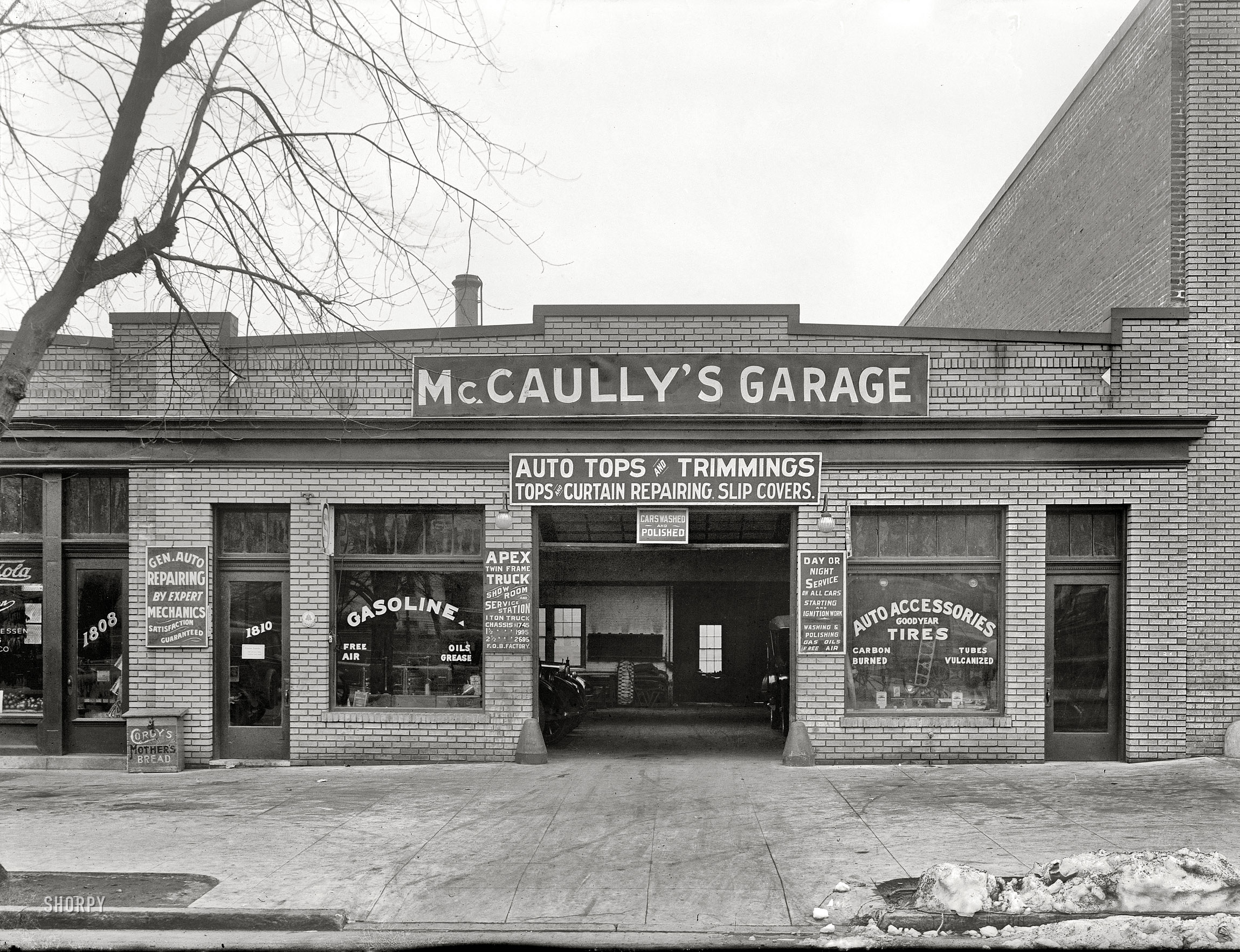 Washington, D.C., circa 1921. "McCaully's garage." Note the bakery-delivery bread box next door. National Photo Company glass negative. View full size.