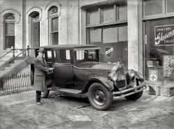 Washington, D.C., 1925. "Glassman (Rent-A-Car Co.)" Former motorcycle cop Herbert Glassman and a Hertz sedan. 5x7 inch glass negative. View full size.
Yellow HertzThe Hertz automobile was a short-lived product of Mr. Hertz's Yellow Cab Manufacturing Co.  Note the "Y" logo on the wheel hubs.  I've never seen a picture of one of these before.
Deer In The HeadlightsNotice the expression on Mr. Glassman's secretary, as seen through his storefront window directly over the car's radiator cap.
In real life1925 Hertz D-1 five-passenger touring car at Auctions America.  Needs some TLC.
Police OfficerHerbert Glassman was cited for bravery during the race riots of 1919. In 1929, he was arrested for leading the city's largest liquor ring out of his rental car agency.
DrivurselfAd from the June 13, 1925, Washington Post. The thrust of the headline seems to be: DOES NOT LOOK LIKE A TAXICAB.
Taxi Boss


Washington Post, June 17, 1972.

Herbert Glassman dies on cruise at 73.


Herbert Glassman, former owner of the Sun Cab Company and the old Black and White Cab Company in Baltimore, died yesterday aboard the Cunard Adventurer. The ship was returning from a cruise to Bermuda.

Mr. Glassman, who was 73, died following a long illness. He was a resident of Norfolk.

Born in London, he came to this country as a youngster and served for several years on the Washington police force. During World War I he served in the Army. After the war he became on of the early operators of a rent-a-car business, affiliating his company with the Hertz organization.

In the 1930's, he became the owner and operator of the City Cab Company and the General Cab Company in Washington. In the 1930's [sic], he became the owner and operator of the Baltimore cab companies. He sold those companies in 1967. At the same time he was active in real estate in Washington and at one time owned the Dorchester House Apartments and the Commonwealth Building. &hellip;

(The Gallery, Cars, Trucks, Buses, D.C., Natl Photo)