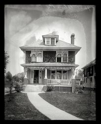Washington, D.C., circa 1920. "7221 Blair Road." Someone's at the door. National Photo Company Collection glass negative. View full size.
Progress?Spacious front lawn with concrete walkway replaced with concave gravel driveway populated with weeds here and there.  Improvement?  Don't think so.
And it&#039;s for sale, tooIt's a small realtors' "for sale" sign to be sure. They probably didn't want to bring too much attention or offend the neighbors.
Wonder what the sale price was in 1920 for this "ample two-story home, good windows (some with screens) and cross-ventilation, breezy shaded front porch, mature plantings, nice lawn and in friendly neighborhood close to paved road."
Not all changes are goodIt's too bad that the sweeping sidewalk is gone, and shame on whomever replaced the twin single-hung windows in the dormer with a single horizontal sliding window.
Old, Simple &amp; EffectiveMy grandparents had the same cloth awnings on the windows, and over the porch. You cranked them up and down by hand with a long metal pole. It was amazing how much cooler the porch got when the awning was down.
1925 or laterOn Zillow it states that the year built is 1925.
Bedrooms: 4 beds
Bathrooms: 2 baths
Single Family: 2,347 sq ft
Lot: 16,176 sq ft
Year Built: 1925
Heating Type: Forced air
Still There!With a few changes, but still very recognizable.
American IconIt's a foursquare!
This house is for saleThe house is for sale, and the negative's mold makes it look like the interior hasn't been dusted for years, there is snow or huge pollen blowing about, and an eerie glow hovers above.
It's gonna be a hard sale!
Owner leaving city.From June 13, 1920, edition of The Washington Times.
Takoma Park
7221 Blair Road
Price reduced $2000
Immediate possession
Owner leaving city. Will sell this beautiful home at a sacrifice in order to make a quick sale. House contains 8 rooms, sleeping porch, breakfast porch and attractive bathroom; entire house is screened including the sleeping porch; hardwood floors; hot-water heat; electric lights; awnings; garage harmonizing with house.
And unfortunately, when you bring up this page from archives, you also see real estate listings for "coloreds" :(
Near Walter Reed Army HospitalJust a very few blocks' walk to the Walter Reed Army Hospital. That must increase the value of houses in the neighborhood. 
Not Near Walter Reed Any MoreWith the coming of BRAC, the Walter Reed Army Hospital was merged with the National Naval Medical Center in Bethesda, MD.  Walter Reed Army Hospital was closed and the old Walter Reed site in D.C. will be redeveloped.
Also, concerning the date in Zillow, if D.C. tax records are like those in nearby Montgomery County, Maryland, the built dates on properties built in the 1930s and before are often wildly inaccurate.  It is not unusual to see newspaper ads for house complete with photos years before the tax records say the houses were built.  In other cases tax records have build dates years before the subdivisions were established.  
We Love Our Foursquare!We live in the historic district of Hyattsville, Maryland; adjacent to Takoma Park. We're a couple of miles inside the Washington, DC, Beltway and a couple of miles from the District line.
There are many of these American foursquare homes in this district. Our home is one of a row of five Sears kit homes on this side of our street built in 1926. The Fullerton model sold then, delivered in two railroad cars, for $2,243. They're going for $250K and above now, depending on condition and upgrades.
Interestingly enough, the story is that in another one of these foursquare homes two blocks from our house, Jim Henson lived when he was attending nearby Northwestern High School. He created his first Muppets for the local Wilkins Coffee company's TV commercials while living there. You can find some of those commercials on YouTube.
(The Gallery, D.C., Natl Photo)