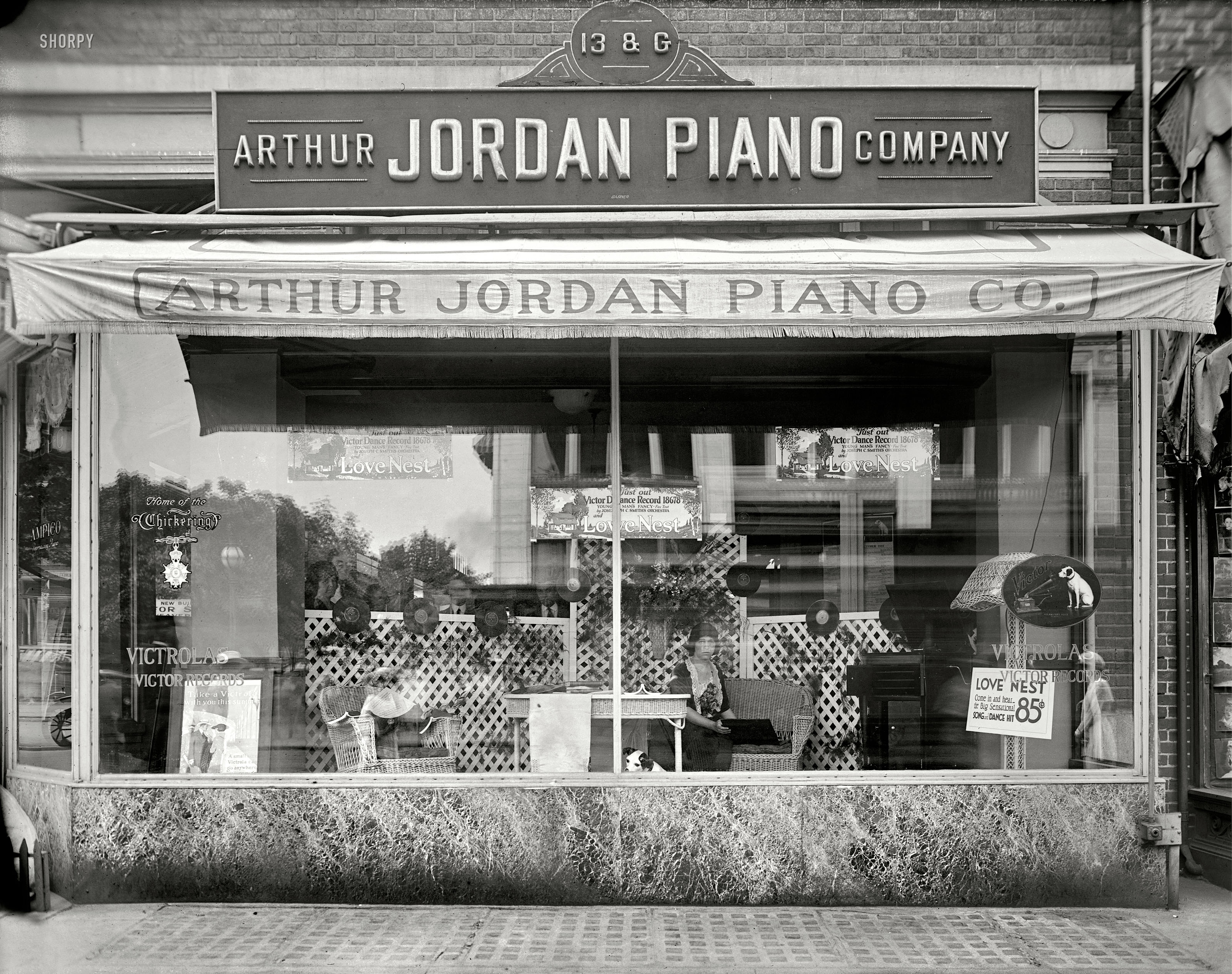 Washington, D.C., circa 1920. "Jordan Piano Co. window." National Photo usually shot its window displays at night to avoid the kind of glare seen here; close study will reveal a number of spectral reflections inhabiting the scene, as well as a row of employees behind the latticework. Plus, Nipper center stage. View full size.