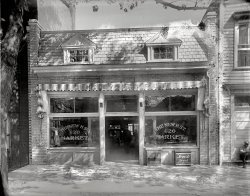 Washington, D.C., circa 1920. "The New H Street 620 Market." Another glimpse of a long-vanished item of urban street furniture, the bakery delivery box. National Photo Company Collection glass negative. View full size.
Corby&#039;s Florida connectionBrothers Charles and William Corby built and grew their bakery into the largest in Washington D.C. in 1920. They were ahead of other bread bakers with automation and were able to deliver 90,000 loaves per day.
Charles died at a polo match in Florida in 1926 and his son also died in Forida in 1937 while vacationing from the bread business. Both had heart disease. Charles was 55 and his son was 44 when they died.
A hard way to live &amp; maybe an easy way to die.This could almost be my Grandad's Grocery on Singleton St @ LeGrande Ave. Indianapolis, Ind. 1924. He was shot down during a holdup in 1925. It was a hard way to make a living, and for an unlucky few, an easy way to die. But for 30 years it provided a family of 4 with a warm home &amp; a fine upbringing for my dad &amp; his sister. Sometimes it is dificult for us to see past the black &amp; white of the photograph, but the ghosts are all there with their own stories to tell, to those of us who can hear them!
Old-time DC bakeriesMore about the history of both the Corby and Bond bakeries, which were located on either side of Georgia Avenue near Howard University, can be found here.
Bakery delivery boxCan anyone tell us, foreigners, how the bakery delivery box worked?
Was it used to deliver the fresh bread to the customers? They could take out and pay later, or how?
Thanks Jess, for the answer!
The Bread BoxAlex, as a former wholesale baker, I can tell you how the bread box worked. 
The store had an account for a set number of loves a day, but the bread was baked at night and delivered at dawn before the store opened. The delivery driver and the grocer both had a key to box. It was a safe place to leave the bread so it wouldn't be stolen before the store opened. 
The grocer would get the bread from the box and sell it in his store. 
Wholesale bakeries in large cities still work like this. At my NYC bakery, our baguettes would be delivered at dawn and, if there was no one to receive the bread, it would be left outside of restaurants until the opening staff retrieved it. If you wander Manhattan around 5:30 AM you will see bags of fresh bread on the sidewalk outside of many nice restaurants! It's a system that works better than you think it might, and we didn't use the old boxes because no one can keep track of thousands of keys if you have thousands of accounts. 
PS- I'm working on opening a small green grocery now, I love this picture!
(The Gallery, D.C., Natl Photo, Stores & Markets)