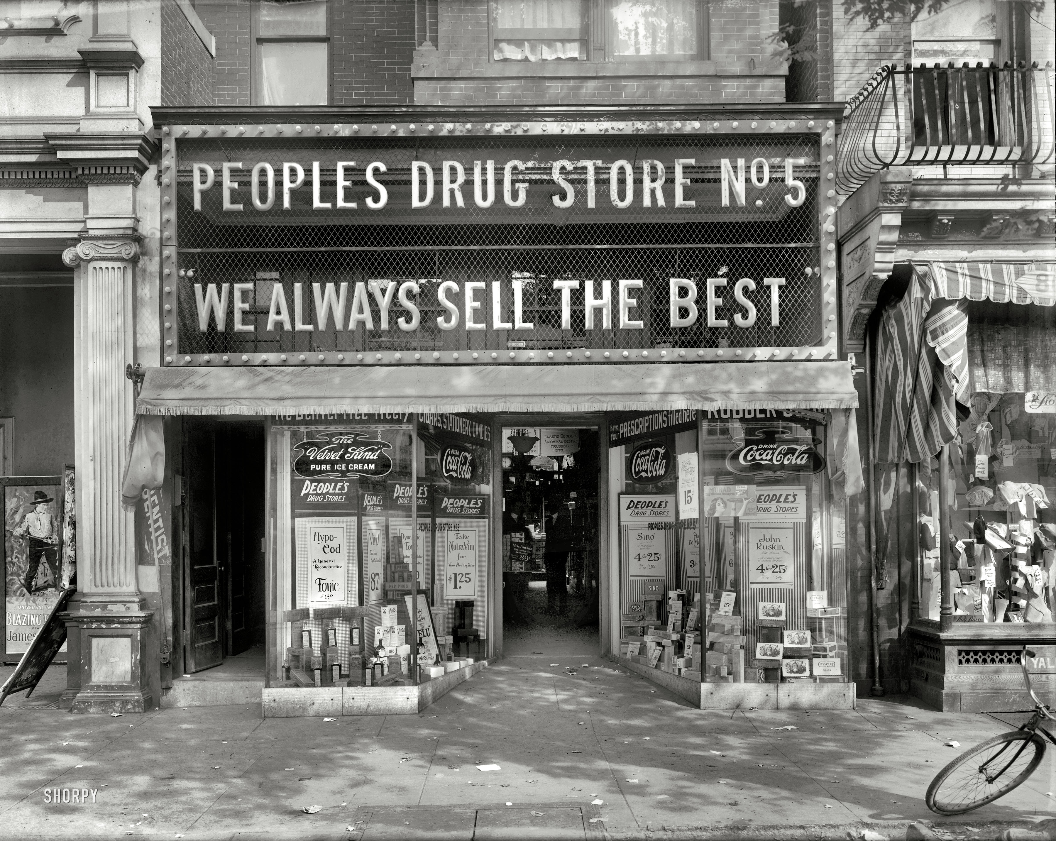 Washington, D.C., circa 1920. "People's Drug Store No. 5, Eighth and H Street N.E." If you're not lured in by the abdominal trusses, cigars or Hypo-Cod, there's always the photoplay next door -- "Blazing the (Something)." View full size.