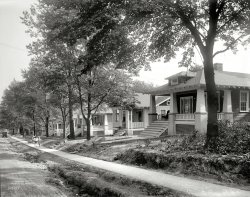 Takoma Park, Maryland, circa 1921. "9 to 11 Elm Avenue." National Photo Company Collection glass negative. View full size.
The &quot;Japanese&quot; bungalowMy favorite great aunt lived in a larger version of these bungalows,  from 1907, and it was one of the most comfortable, light, airy, commodious and well-thought-out houses I have ever been in.  She and my great uncle bought it in 1952 or so. About the only real change they ever made was to screen in the front porch at some point. 
Variety is the spice of life!What I find fascinating in this photo is there are 5 different styles of porch posts/pillars which is wonderful to see.  So different to subdivision homes these days.  From large cylinder columns to large square ones to smaller squares to pyramidal and then trellis style, the houses may be similar in plan, but so much thought has gone into making them seem unique.  (And the rocker is facing the porch next door so it seems neighbours were really neighbours then!)
Thanks Shorpy!I have very fond memories of this stretch of street from when I lived there thirty years ago. Not many of those bungalows remained even then.
Brand New!!The contractors are not even finished yet, and the new owners are hangin' out on the porch already! New sidewalks and I'm sure curbs and a new road are not too long in this neighborhood's future. But where will the driveways be? It is 1921 and a garage should also be waiting for the family sedan.
Round the backIf there was a garage, it was off the alley that ran along the back of the houses, parallel to the street. That put the unsightly cars out of sight of the street. 
Thanks to googleand Gordon61 I found the place, most of the houses are still there, and there are no back alleys but now people have added small driveways to their houses. I guess houses were built to last back then.
A Brief History of the Home GarageThough obviously some homes were built with garages and driveways during the 1920's, it was not at all considered a standard home amenity until after World War 2. The early garages tend to be converted carriage houses and in a separate structure than the human living quarters so you didn't have to smell your horses and goats in your kitchen.
My parents have an amazing 2 story 3 car garage in the back yard of their 1920's home. It came with a pot belly type gas stove in one bay (obviously no car could go there) because the original owner had a pet donkey that needed to be kept warm in the winter.
A house I grew up in that was built in 1920 had a Sears Catalog kit garage in its back yard, facing an alley. It was added in 1927 and still had the stock numbers stamped on the boards to help one put it together. No driveway led to it. Only one car could park in it even though it was Sears deluxe 2 car model because the proportions of 1920's garages were tall and narrow like a Model T Ford.
I suspect the homes on this street will get no garages unless the owners separately chose to put some in. 
The attached garage in the same building as the home (where zoning laws permit--not all do) becomes a standard amenity with the WW2 GI bill housing boom. But even then, whole communities were built without garages. The Jubilee model of baby boom homes in Levittown Pennsylvania comes with garages. The other models get driveways with carports only.
Street has changed. Houses still thereLooks like the street has changed to Westmoreland Ave.
View Larger Map
Milk bottlesAt the base of the stairs of the nearest house, it looks like two empties waiting for the milk man.
I have always loved that architectural style of house.
Re: &#039;Japanese Bungalow&#039;Always learning something new on 'Shorpy'!
You can see the Asian Influence...now that 'claiborneray' mentioned it.
This design must have been very modern and unusual in that day.
Amazing photo of a beautiful streetaenthal:
Thanks for your comments. Very interesting indeed. It would be wonderful to have one of those Sears homes/garages that you mentioned. As for these homes, this is one of my favorite architectural styles, although in Houston, most of them have been torn down or are now priced out reach for the average Joe.
(The Gallery, Natl Photo)