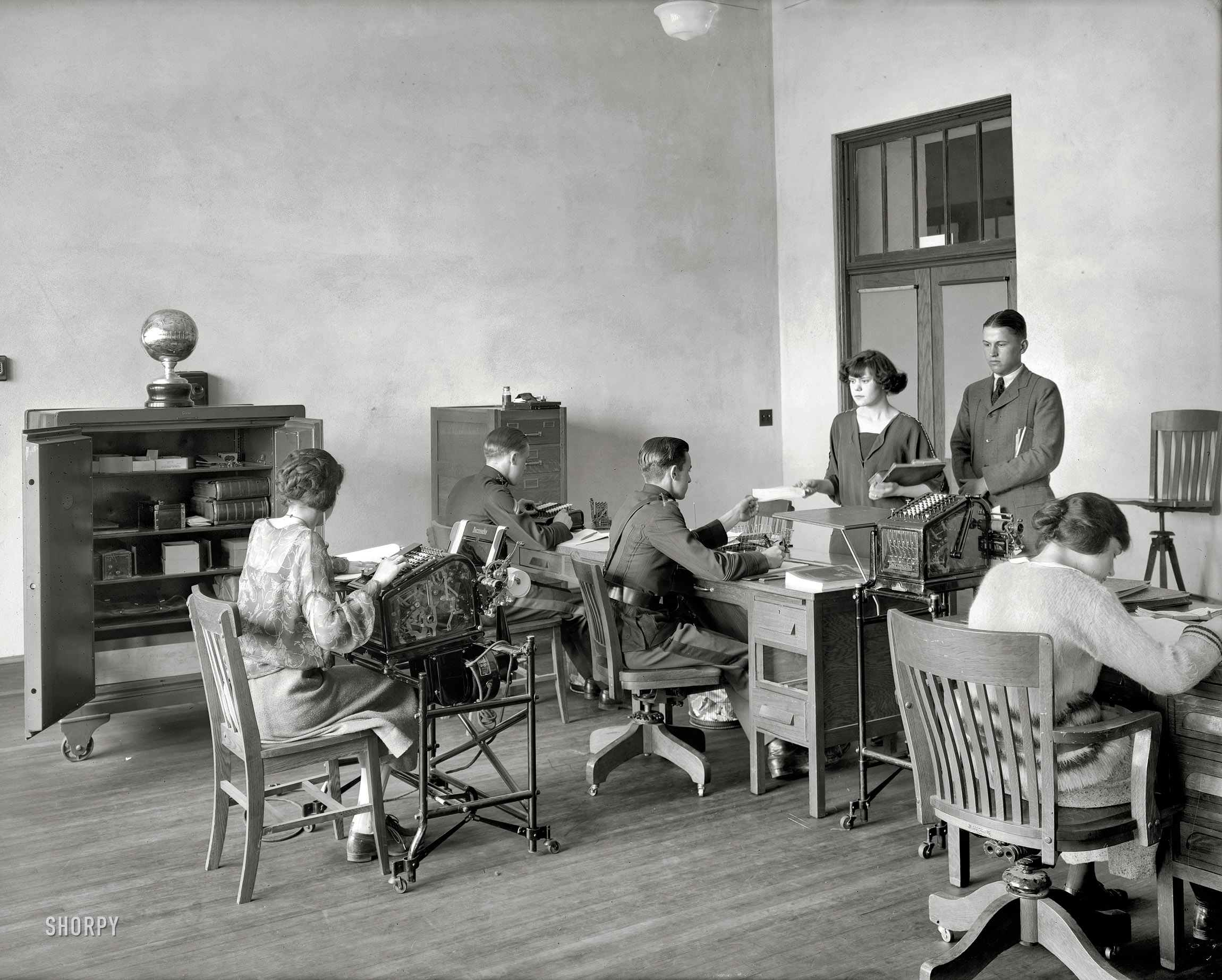 Washington, D.C., circa 1923. "Eastern High School -- bank." Note the see-through Burroughs accounting machines with glass sides, and sports trophy on the safe. National Photo Company Collection glass negative. View full size.