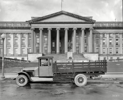 Washington, D.C., circa 1925. "Graham Bros. truck at Treasury -- Gen. Serp Corn." Which is how some overworked archivist at the Library of Congress has transcribed the label on this glass plate. National Photo Co. View full size.
Impressive and unimpressiveIt looks good, but, no spare tire - just a rim?  Also, look at that wimpy driveshaft, but then I'll bet it's solid, rather than tubular.  A lot of wood there, especially the risers for the stake bed, atop the frame.  No rust worries, just rot worries.  And, you'd be disgruntled, too, if you had to drive a truck with a non-synchro gearbox.
General ShorpyThat truck is calling out to be reassigned to the General Shorpy Committee! Is there a sign painter in the house?
Good enough for government work?Not much to talk about here except that the driver did a poor job of affixing the stake sides (see left rear; the hooks are not properly engaged).  
Spiffy!Then as now, your tax dollars at work -- brand-new and super shiny, looking like a $50K restoration from an automotive reality show on cable. (Even the leaf springs are perky!) A real treat, complete with an authentic accessory -- a disgruntled and uninterested government contractor behind the wheel.
Wanna Buy a Truck?My guess is that this is the new Dodge Brothers version of the Graham, and this photo was basically an ad to sell Graham trucks, possibly sent out in the form of a press release.
"Ray, Joseph and Robert Graham were born into an Indian farm family. They got their start in the auto industry by converting Ford cars into one-ton express or stake trucks using a rear axle of their own design. They soon graduated to the manufacture of truck bodies for passenger car chassis and were offering their own line of trucks by 1920. Their success attracted the Dodge Brothers who were looking to enter the truck market. Through a deal signed in 1921, the Grahams built trucks solely wîth Dodge engines and drive trains, for sale exclusively through the Dodge dealer network.--
Source - AACA Museum
Rag top commercial truck?There are not many folks alive today that can say they remember that!!  And how about the spare RIM in the back...no tube or tire, but at least the guy has a rim to ride on should one of his rims crack!
Graham Brothers , Dodge, &amp; ChryslerGraham Brothers was not bought by Dodge until October 6, 1925, but even after that date the large trucks were still labeled as Graham Brothers (look at the hub caps).  The underslung rear spare tire carrier indicates that this truck was built after June 23, 1925.  Firsts for these models included all steel construction, crank operated windows, automatic windshield wipers, and a tray for manuals, books, etc. above the windshield.
The Treasury Department truck cost about $1600 in 1925.  Adjusted for inflation the cost today would be about $21,500 (MSRP of a base 2013 Dodge Ram pickup is about $23,500).  The 1 1/2 ton truck had a wheelbase of 158 inches which allowed a full 12 feet X 5 feet of storage space in the bed.
The stake sides are properly engaged.  The rear-most section of stakes is warped/not square.  Notice how the posts for this section are leaning to the right, and that there is a gap between the center section and the rear section of stakes (with a wider gap at the top than the bottom).
The design of the sides is such that the center section can be lifted out while leaving the other side pieces in place.  This permits loading and unloading from the side of the vehicle which was a common practice in the day - especially in narrow alleyways.
As for the driver, you might be a little disgruntled too if everyone was telling you where to go every day.
Without Ostentation


Washington Post, May 10, 1925.

Rank First in Sales in 1&frac12;-Ton Trucks


Official figures from Detroit for the first quarter of 1925 show that Graham Bros. rank first in the world in the production and sale of 1&frac12;-ton trucks. In the 1-ton and 1&frac12;-ton truck fields combined they were surpassed in volume only by Ford.

 &#8220;The information may be surprising to the general public,&#8221; said Raphael Semmes, local Dodge Bros. dealer, &#8220;but not to us nor to those who are familiar with the performance of Graham Bros. trucks and with their rapid ascendancy in the industry during the last three years. Their advance has been without ostentation. There has been no blare of trumpets, no exaggerated claim. It has been a steady, wholesome growth, based entirely upon the trucks' performance.&#8221;

Less than three years ago Graham Brothers were in twentieth position. Now they are manufacturing trucks at the rate of over 100 a day, marketing their entire output through Dodge Brothers dealers. &hellip; 
(The Gallery, Cars, Trucks, Buses, D.C., Natl Photo)