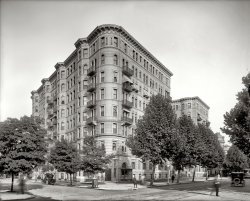 Washington, D.C., circa 1925. "Stoneleigh Court." Passers-by, frozen in time. National Photo Company Collection glass negative. View full size.
One-Legged TrifectaThree one-legged ghosties in one pic. 
[There are at least four one-leggers.]
A mere 57 year lifeKind of amazing at the lifespan some of these great masonry buildings had; short ones I mean. 57 years is just barely "broke in".
A Beautiful BuildingHere's more information on this great building which is now sadly gone:
http://greatergreaterwashington.org/post/2618/lost-washington-stoneleigh... 
Beautiful Fire TrapsAlas, the razing of these beautiful masonry buildings had less to do with beauty and more to do with safety. A series of particularly lethal fires in the 40s and 50s, such as the Chicago Our Lady of Angels fire in 1958, led to much stricter building and fire codes being implimented in the US. For most buildings built before World War I, it wasn't financially feasible to retrofit the buildings to make them safe. Most were torn down to make way for safer, albeit uglier, structures.   
WeepyAlthough I didn't "join" immediately, I've been viewing Shorpy since the beginning.  You would think I would be used to finding out that the buildings we are looking at are gone.  Apparently not.  When I saw this one, I set to packing and calling the moving company.  Vonderbees caught me just in time, and I'm sitting here in tears.  Sigh.  Fire hazard, whatever, they always find an excuse. 
It was demolished in 1965Stoneleigh Court, completed in 1902, was home to many Washington notables over the years, including Supreme Court Justice Louis Brandeis.  The view above shows the corner of Connecticut Avenue on the right and L Street NW on the left.  The Blake Building went up on the site in 1966 and maintained a little hint of the Stoneleigh Court appearance.
(The Gallery, D.C., Natl Photo)