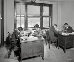 Washington, D.C., 1925. "Justice Department, Nat'l. Bureau of Identification." Filing fingerprints at the forerunner of today's FBI. View full size.
Until J. Edgar Hoover took overThe Justice Department's Bureau of Investigation was nothing to brag about.  Almost anyone with connections could be a field agent, and the quality of the furniture in this photo reflects the Bureau's stature in the Federal bureauacy.  Agents were poorly paid, poorly trained and had to depend on public transportation to get to the scene of the crime.  Hoover changed all that, eventually turning a lowly haven for slackers into the world's greatest criminal investigative force, the Federal Bureau of Investigation.  Hoover had just started as Director when this picture was taken.  A few years down the line, a cigarette butt on the office floor could lead to a 10-day suspension!
The girl on the leftThe first thing I noticed was the unusual haircut and clothing style of the young woman on the left for the time.  The other three people in this picture look very 1925, but the left-hand woman looks like she's out of 1960s London. 
Hard at WorkThere they are looking for Anarchists, Bolsheviks and any others looking to overthrow the status quo. 
The girl on the left, 2Haven't you ever heard of Lulu Brooks jms? That hair cut and drop waist dress screams jazz age!
Sparse Furnishings!The room is rather bare, the desks look very old and scratched and have been placed next to the windows to take advantage of the natural lighting.
The Bureau did not seem to spend a lot of money on workplace amenities. Is that is a cigarette on the floor by the girl on the left (no ashtray on their desk!) although the men seem to have one.
Guess I&#039;m spoiled and greedyI couldn't imagine having to share my desk with somebody else.  That's some mighty close quarters, there!
Working in the backI find the double-sided desks most interesting. I can see the woman on the far left has drawers, but unless the man in the middle has some on the opposite side from the way her desk is built, he just gets to work on the backside of the other guy's desk.
WinterLooks like a cold, snowy day outside. 
Name?Lulu? You perhaps mean Louise Brooks?
[It's her common nickname, used by herself in fact, in her memoir Lulu in Hollywood. - tterrace]
(The Gallery, D.C., Natl Photo, The Office)