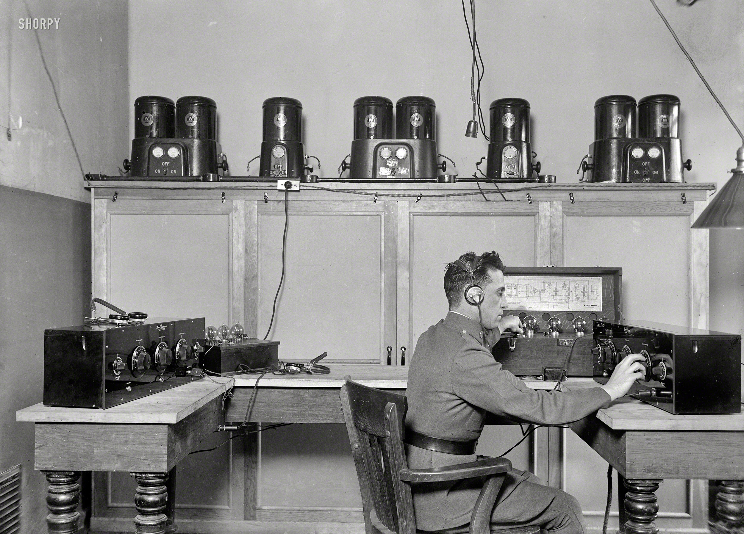 Washington, D.C., 1924. Tweaking the dials on a Freed Eisemann Neutrodyne receiver and a Western Electric 138 amplifier. On the shelf: Westinghouse "Rectigon" battery chargers. Harris & Ewing glass negative. View full size.